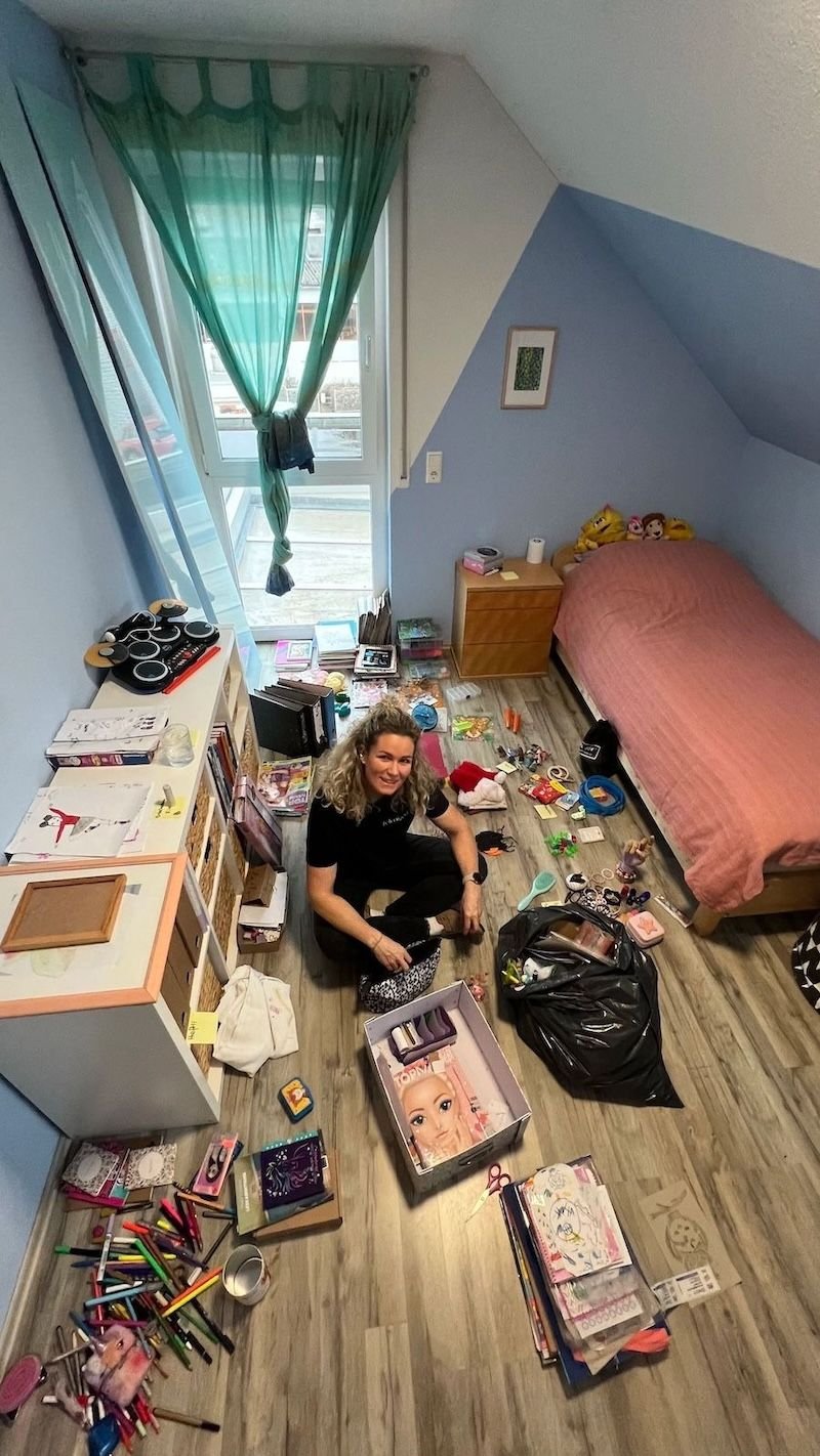 Felicitas Geppert beim Ausmisten eines Kinderzimmers: Stifte, Spielsachen und Bastelmaterial sortiert auf dem Boden