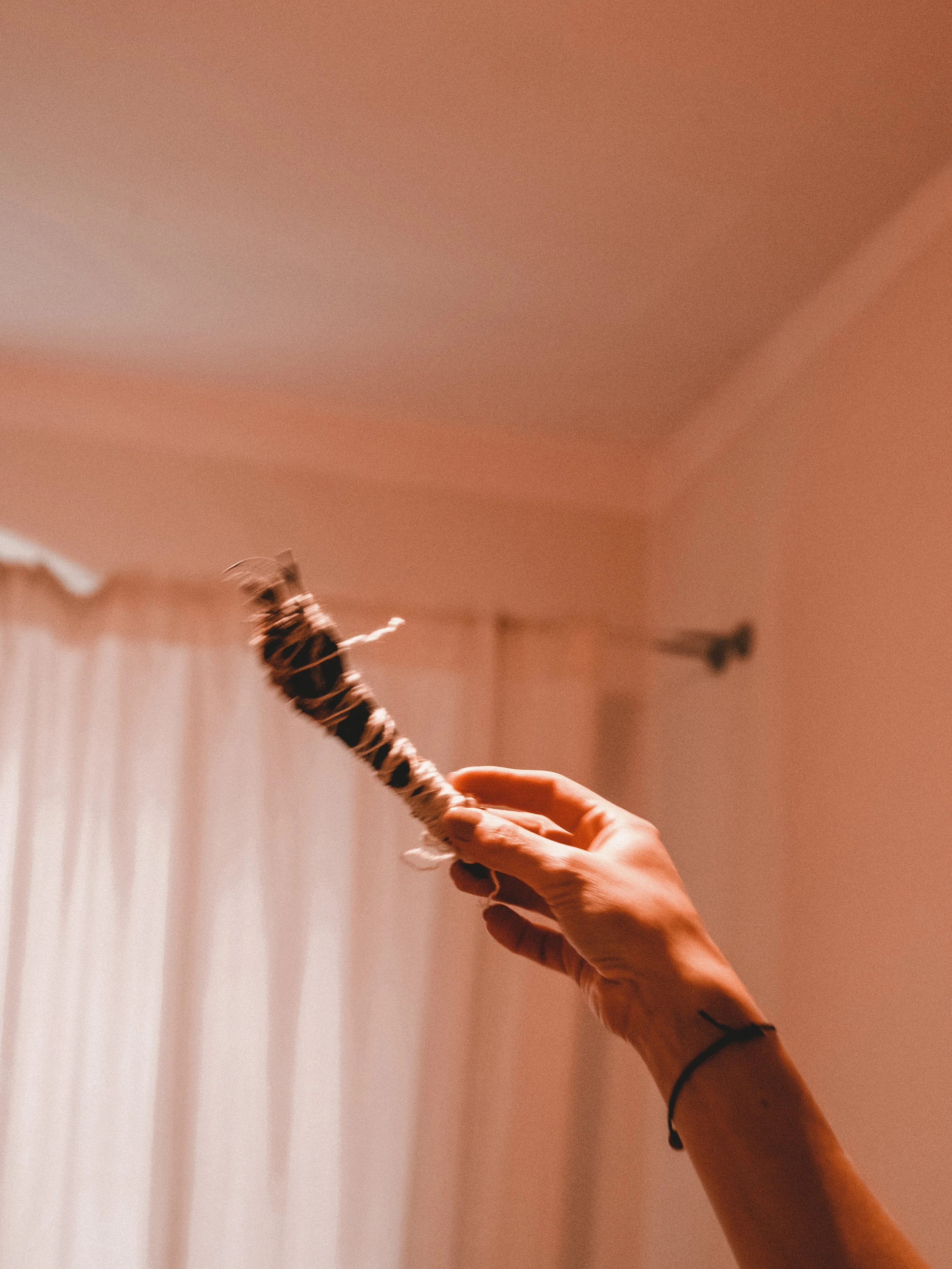 Hand holding ignited sage stick during a Kobido ritual in Berlin.