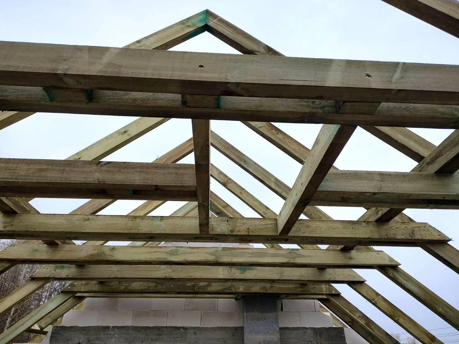 Drewniana więźba dachowa domu jednorodzinnego – konstrukcja dachu w trakcie budowy, widok od dołu