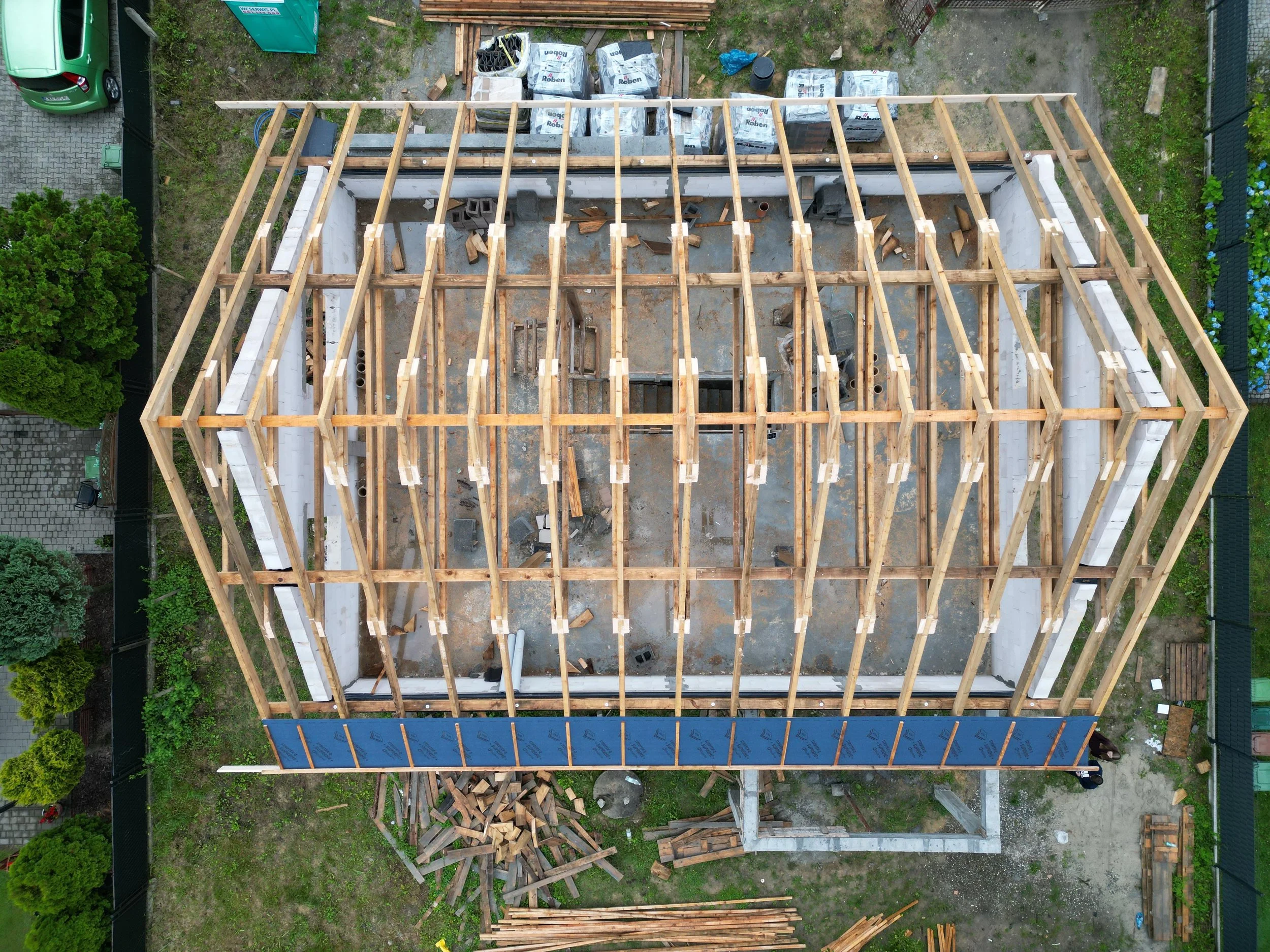 Budowa domu jednorodzinnego – drewniana konstrukcja więźby dachowej widziana z góry, etap montażu dachu