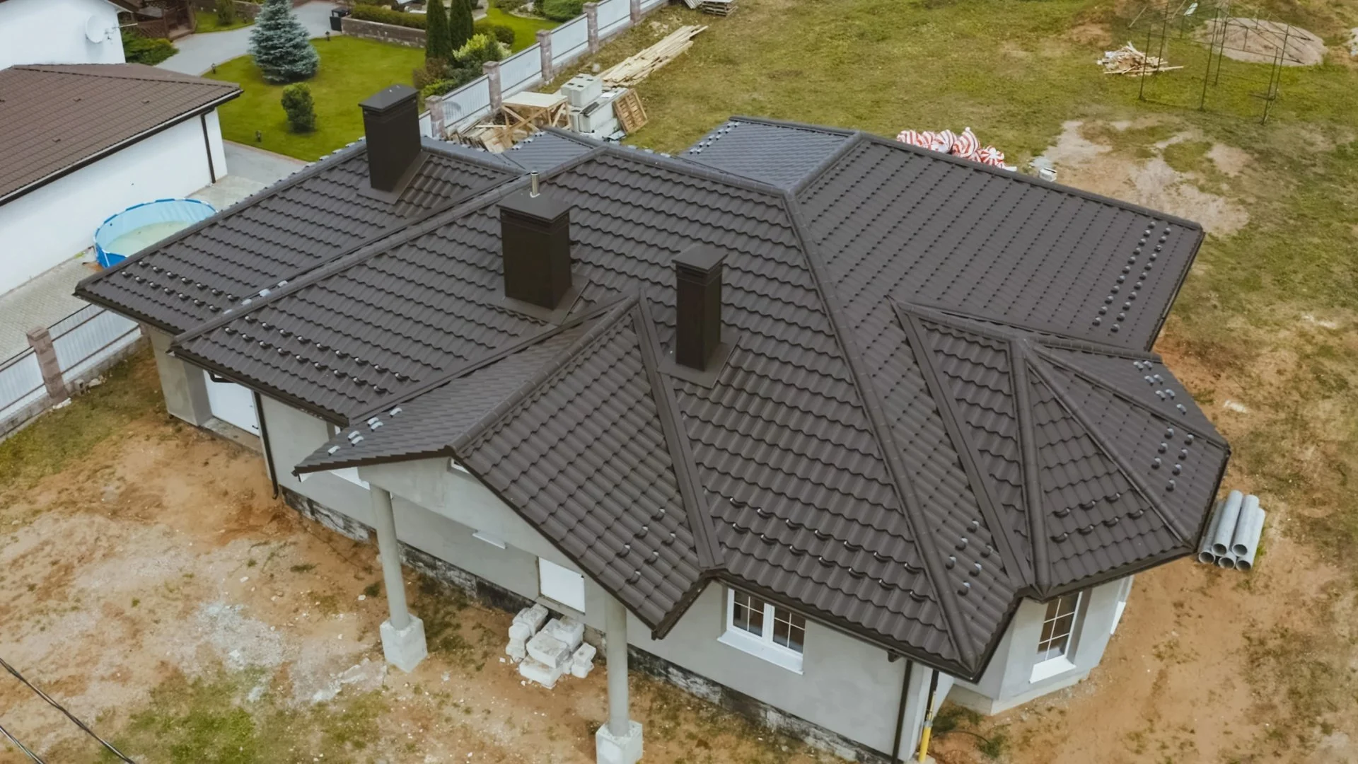 Dach domu jednorodzinnego z dachówki ceramicznej widziany z lotu ptaka podczas budowy