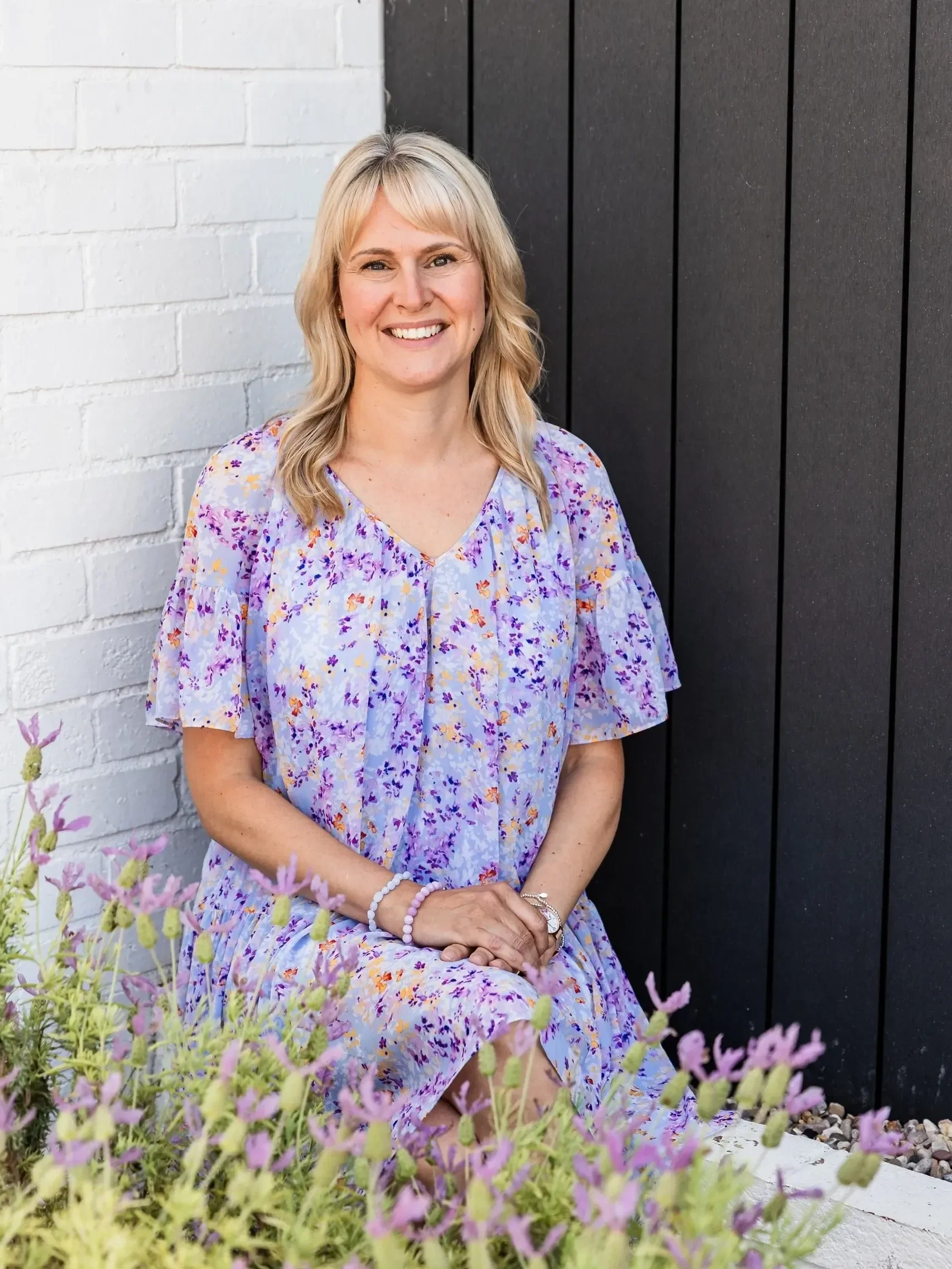 BrightSpark client, Sarah, pictured on a sunny outdoor terrace.