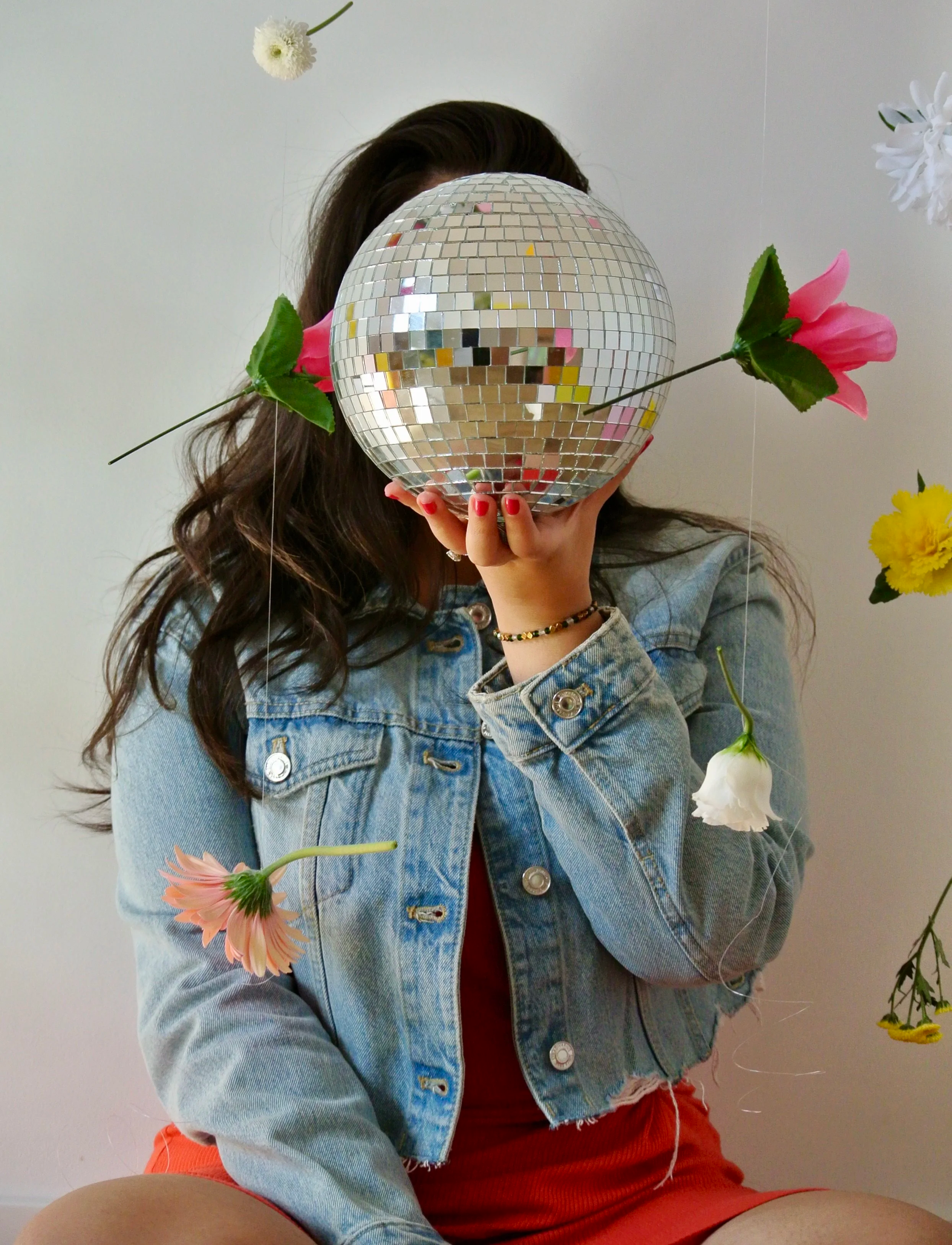 Photo of Ariel De La Mora with flowers and a disco ball