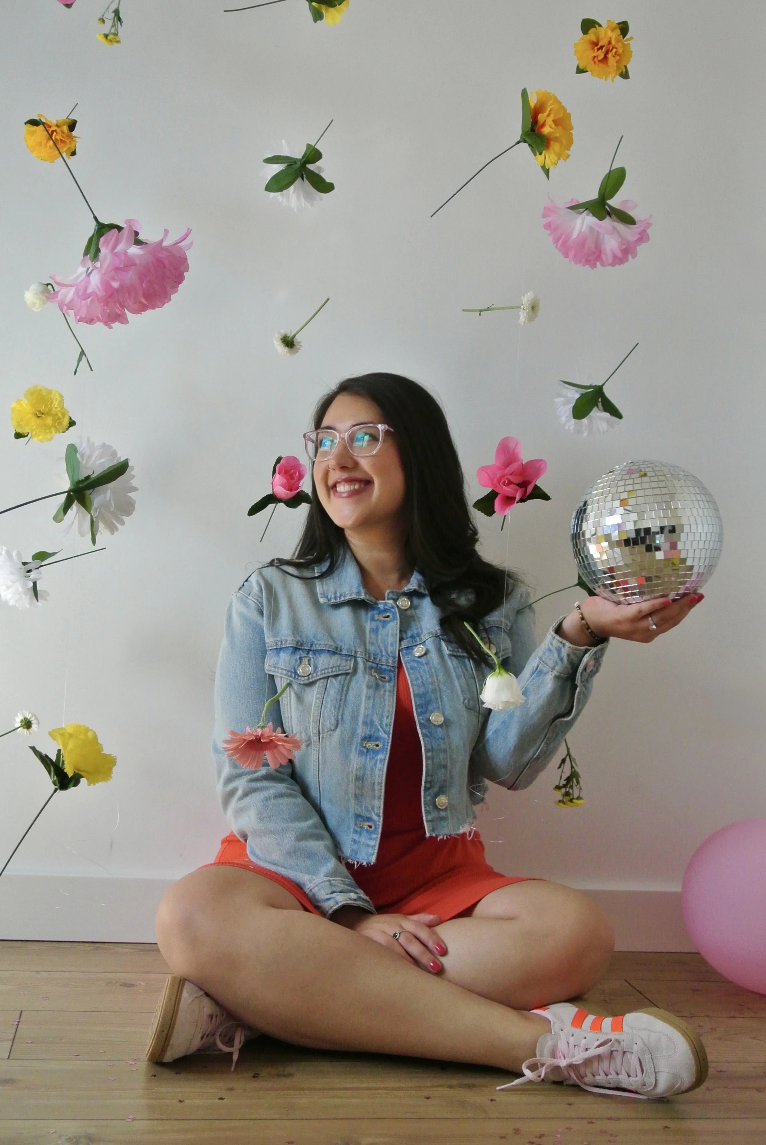 Photo of Ariel De La Mora with flowers and a disco ball