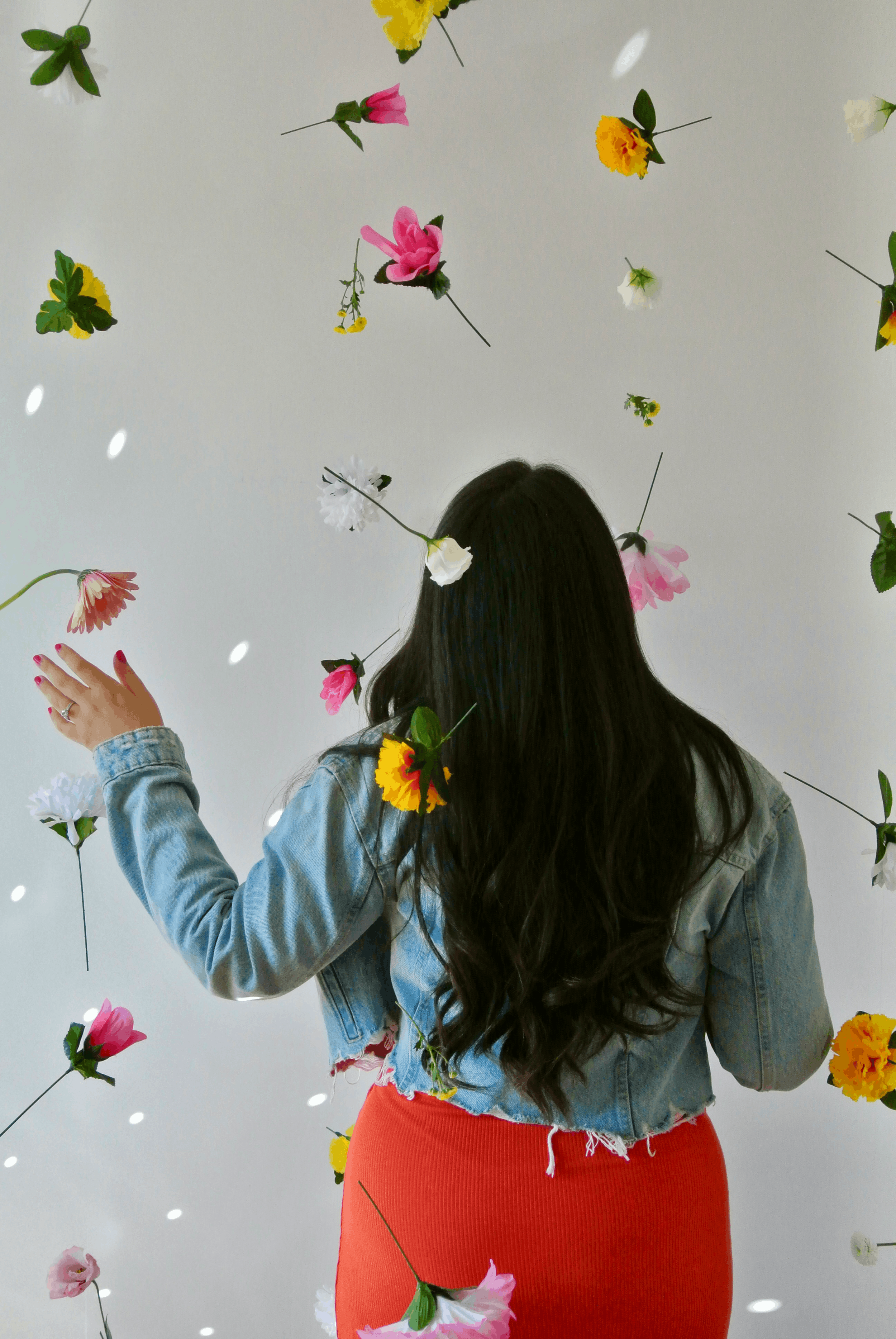Ariel De La Mora surrounded by flowers from behind