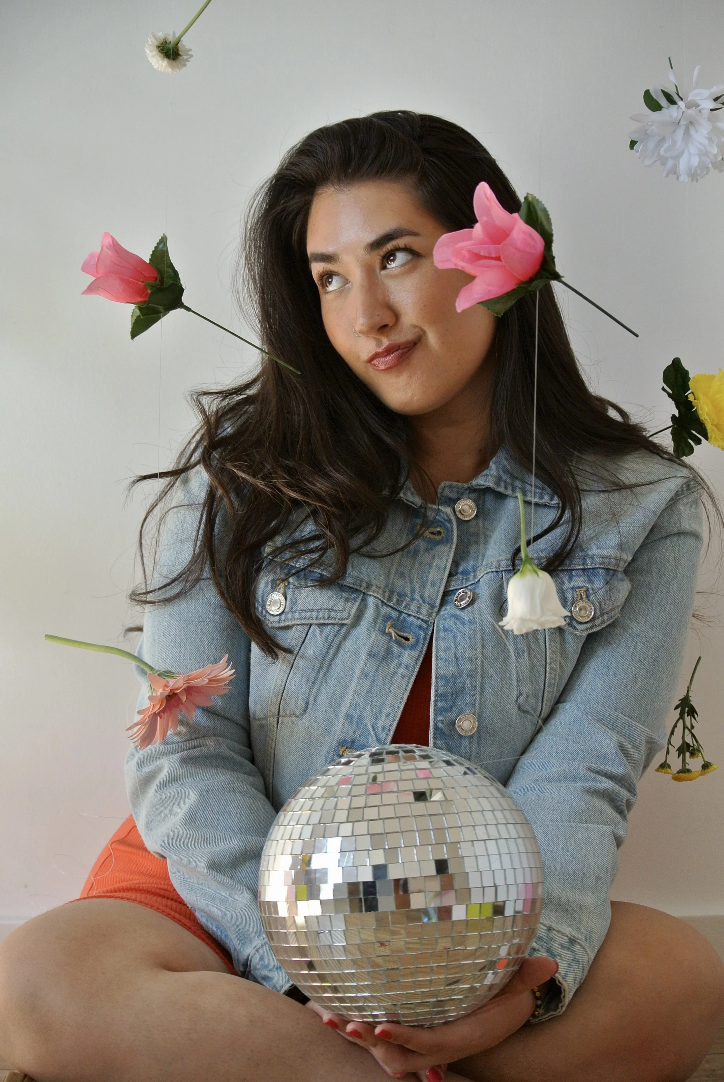 Photo of Ariel De La Mora with flowers and a disco ball
