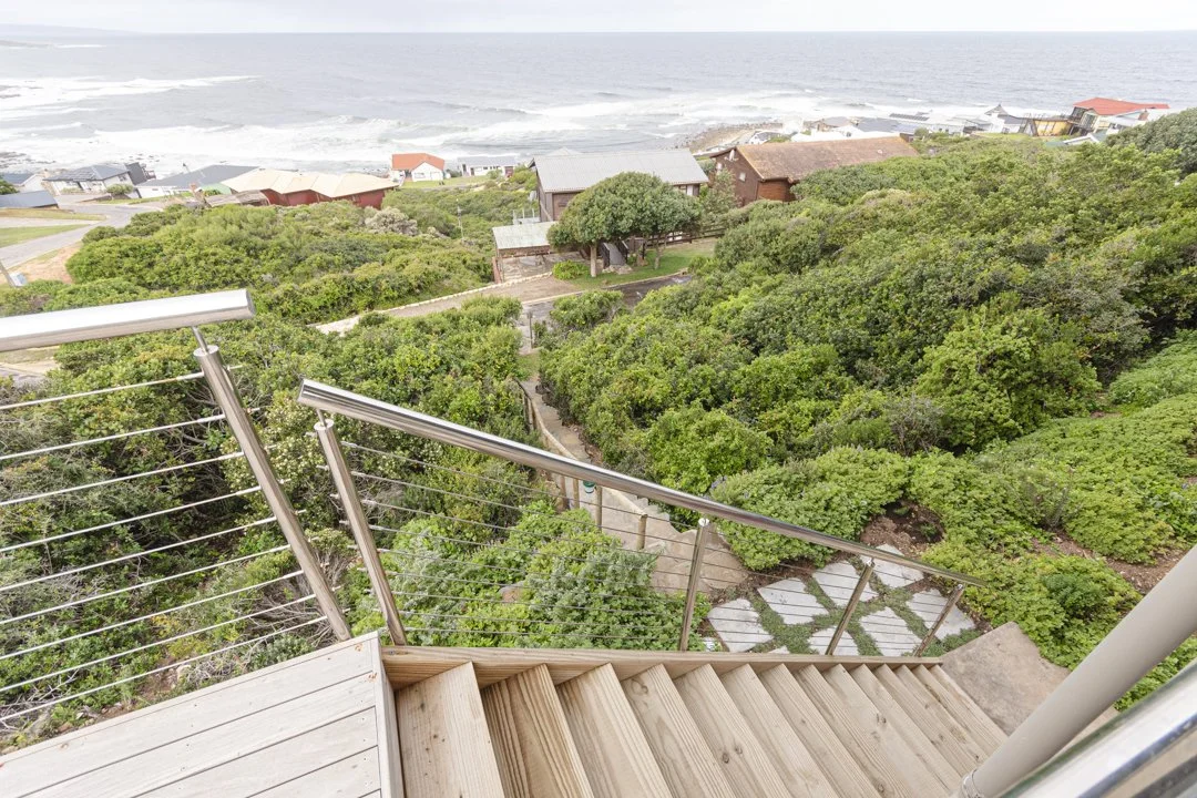 Wooden stairs leading down to the garden and access to the pathway that leads to street in front.
