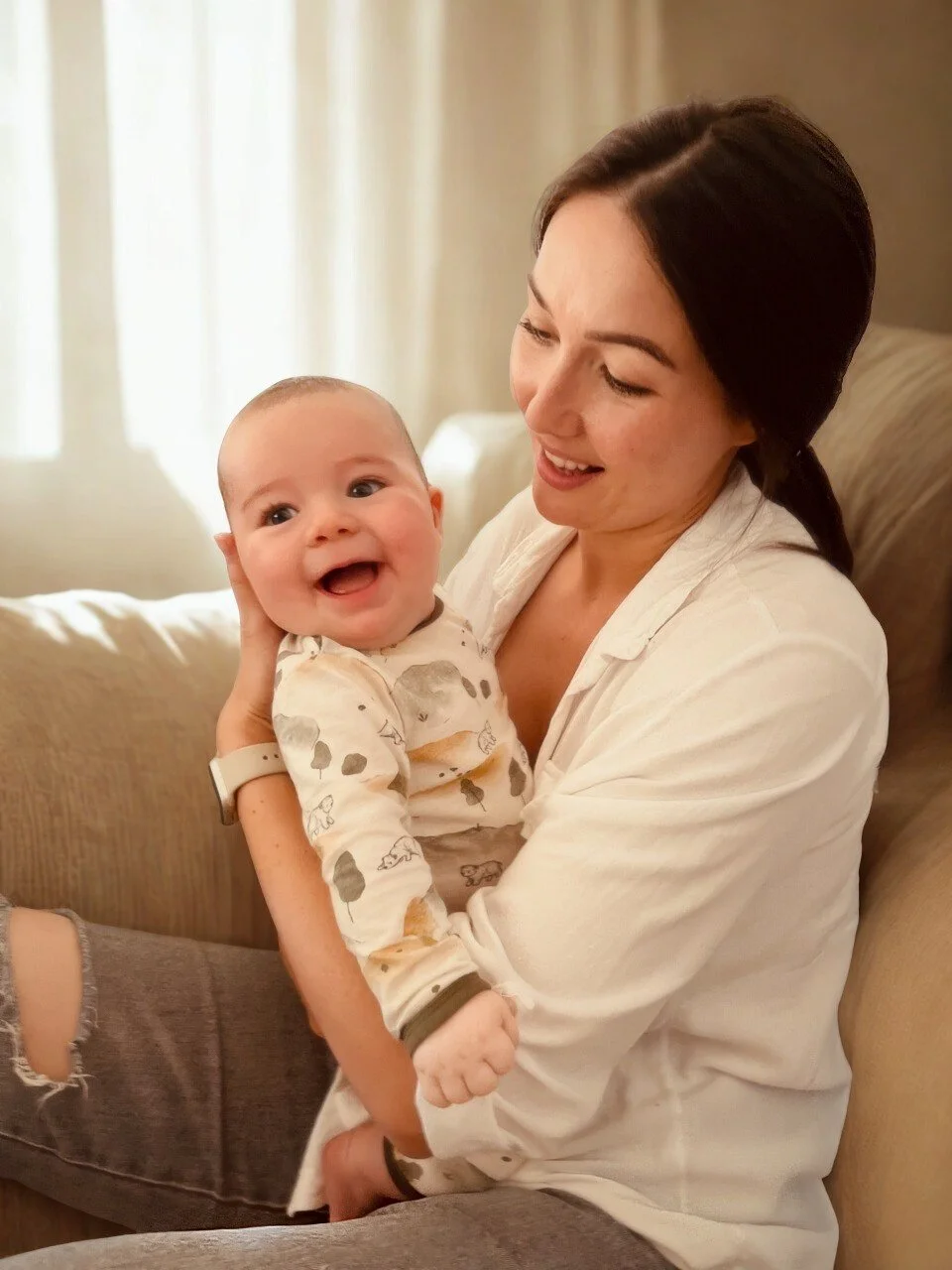 Osteopath, Dr Caitlin Gill from Mount & Valley Osteo sitting holding her baby