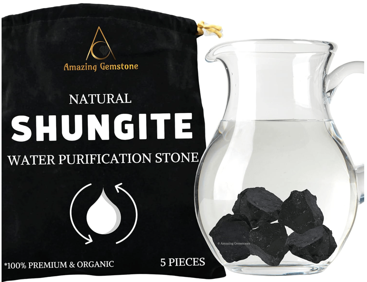 A black bag labeled 'Amazing Gemstone Natural Shungite Water Purification Stone' with five pieces of black shungite stones inside, next to a glass pitcher filled with water.