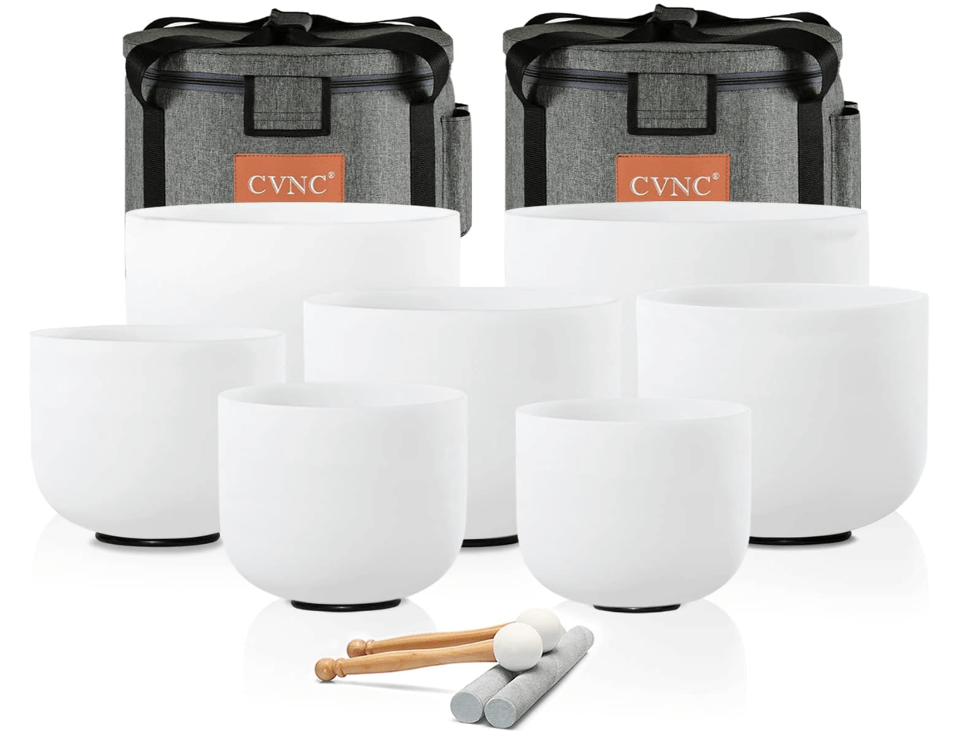 A set of six white sound bowls of varying sizes accompanied by mallets, with two gray carrying cases in the background.
