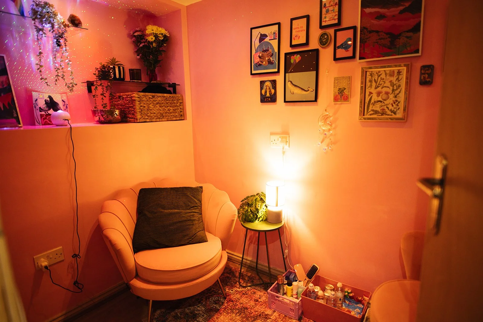 A pink armchair with a green cushion and green sidetable