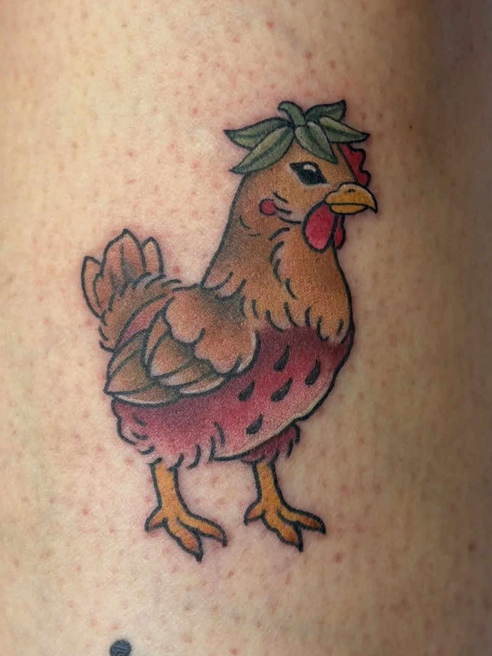 Whimsical strawberry chicken tattoo with bright red berries and playful neo-traditional detail