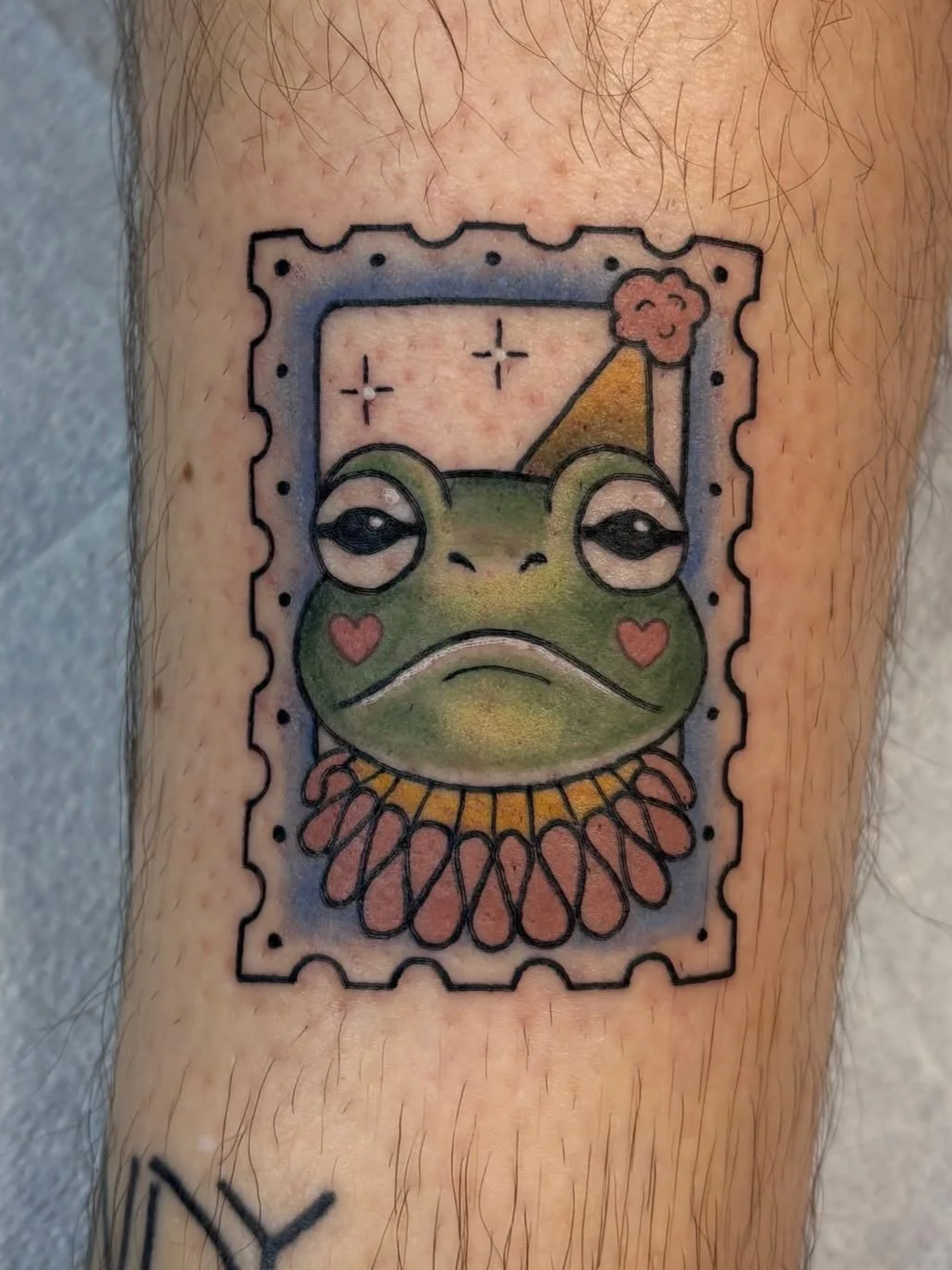 Whimsical clown frog stamp tattoo with playful linework and vintage-inspired detail