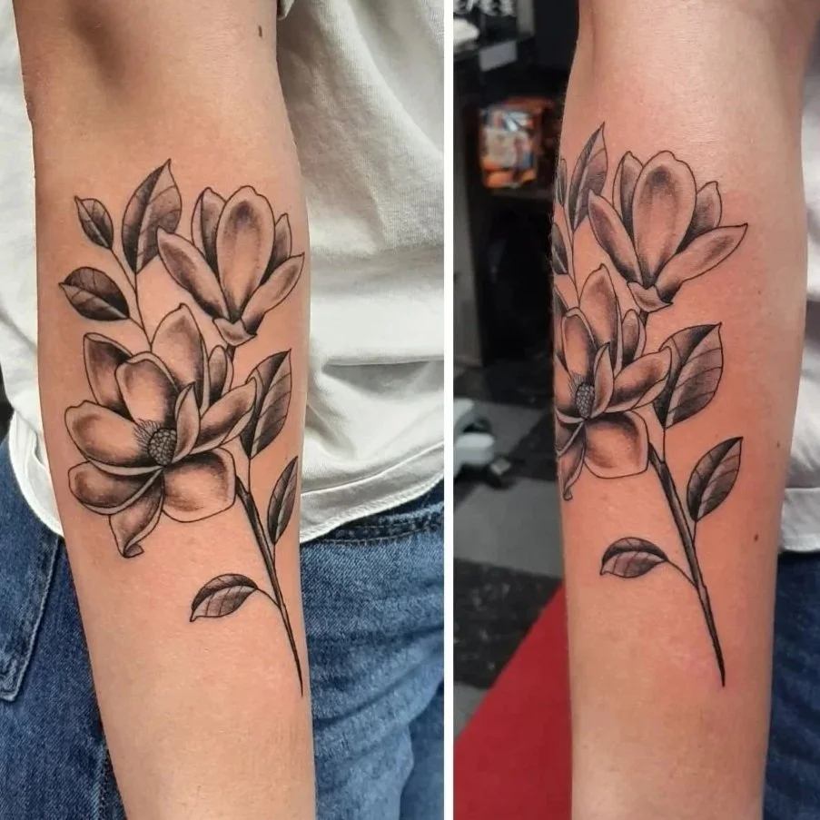 Black and grey magnolia tattoo with soft shading and detailed botanical linework