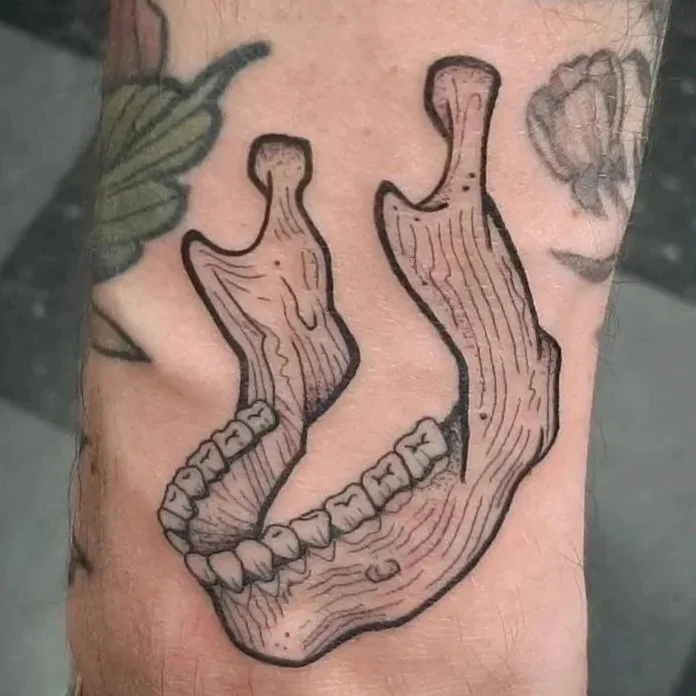 Illustrative jawbone tattoo with crisp outlines and detailed linework