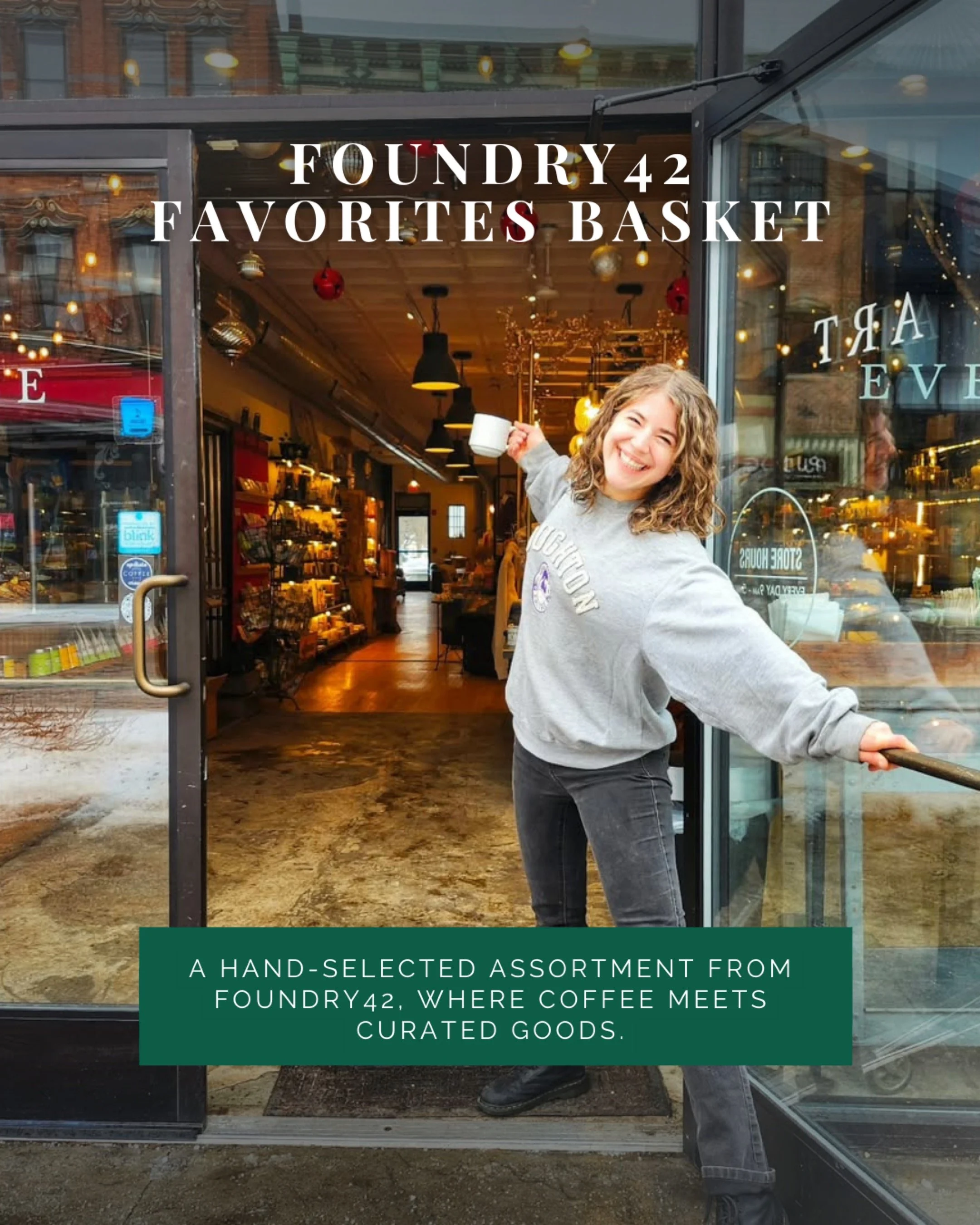 A woman with curly hair smiling and holding a coffee cup standing in the doorway of a coffee shop called Foundry42, with the shop's interior visible in the background.