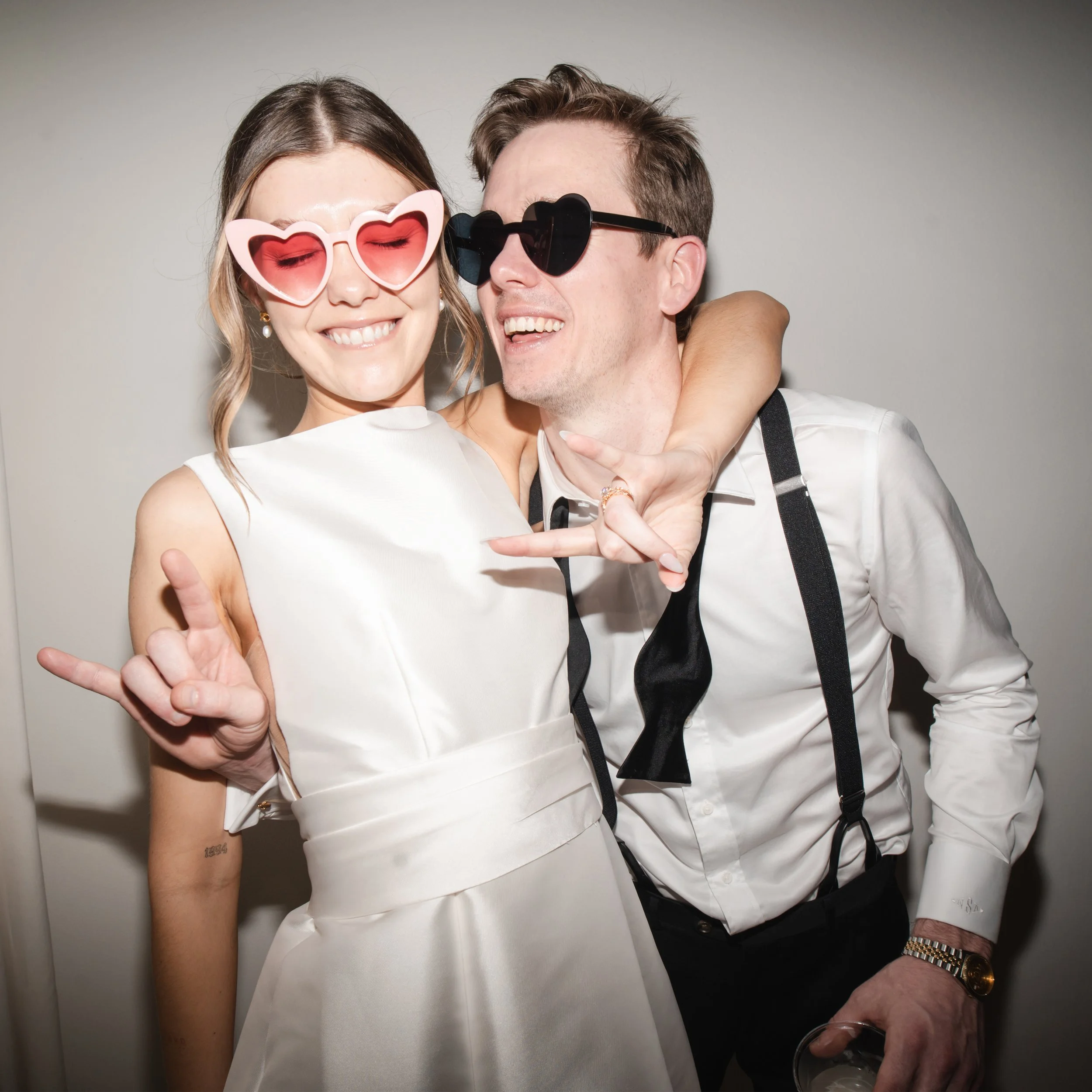 Fun Austin wedding photo and video portrait of a couple wearing heart sunglasses during their reception