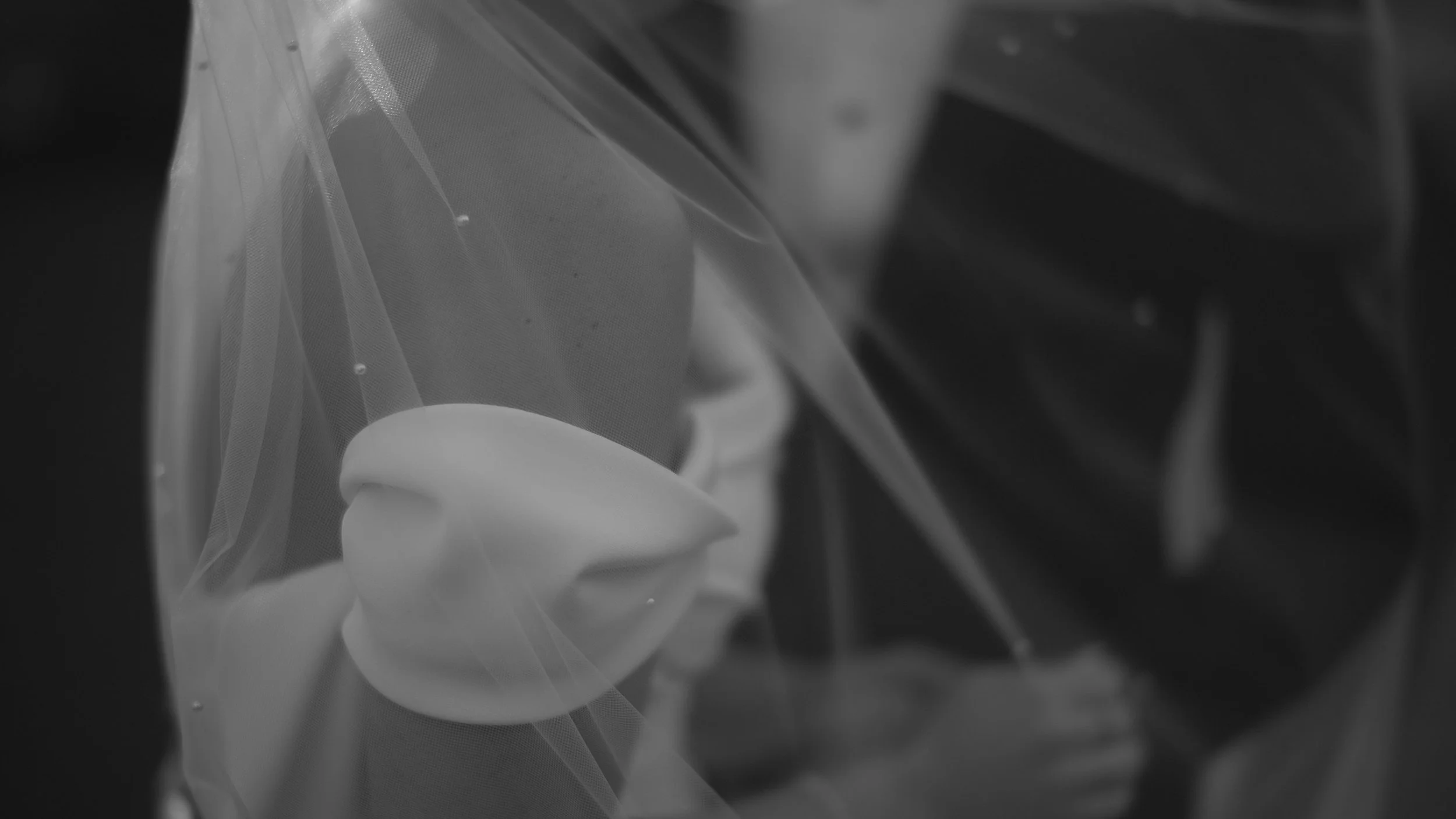 Black and white Austin wedding videography still showing a close-up of a bride’s veil and shoulder detail