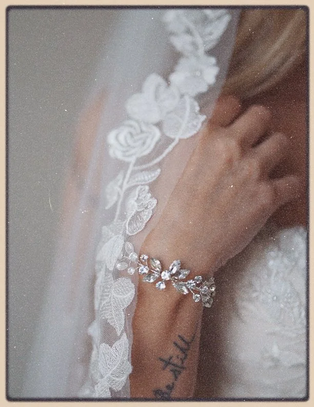 Soft documentary style wedding photography detail of a bride’s lace dress, bracelet, and veil in Austin