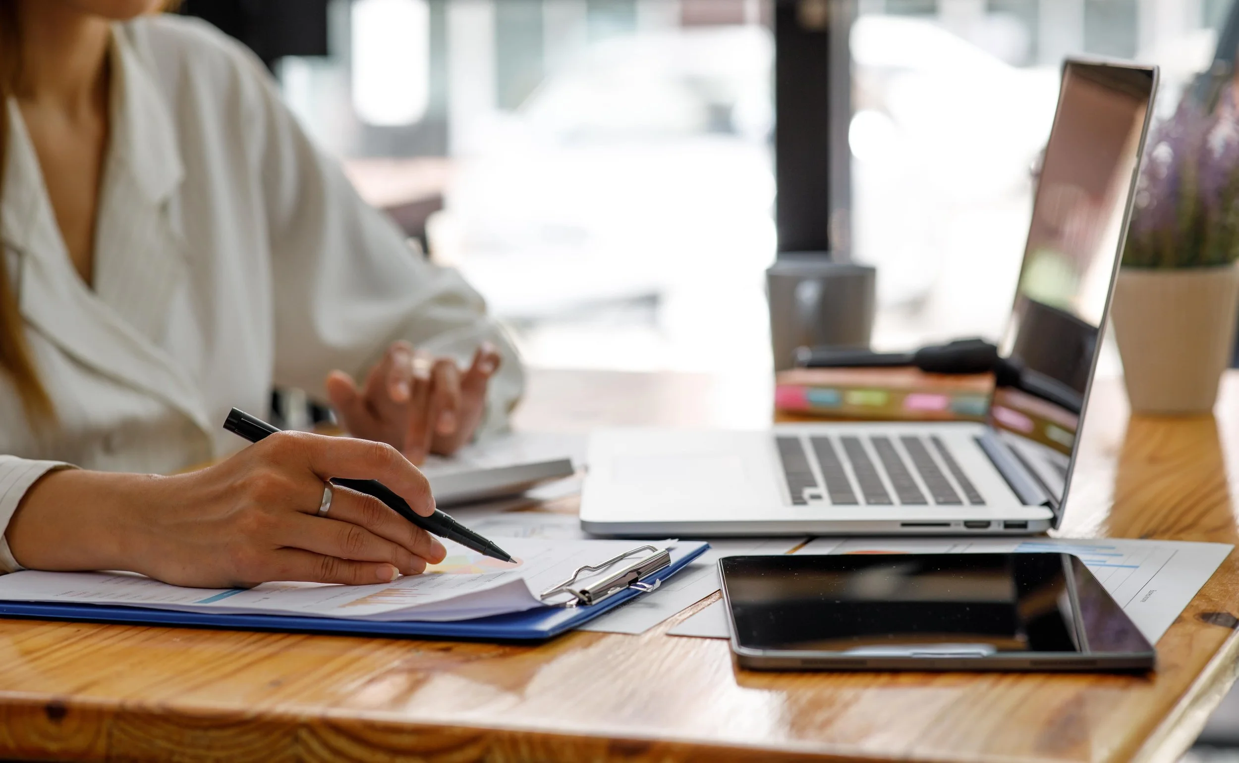 Woman working on laptop while preparing tax and accounting documents