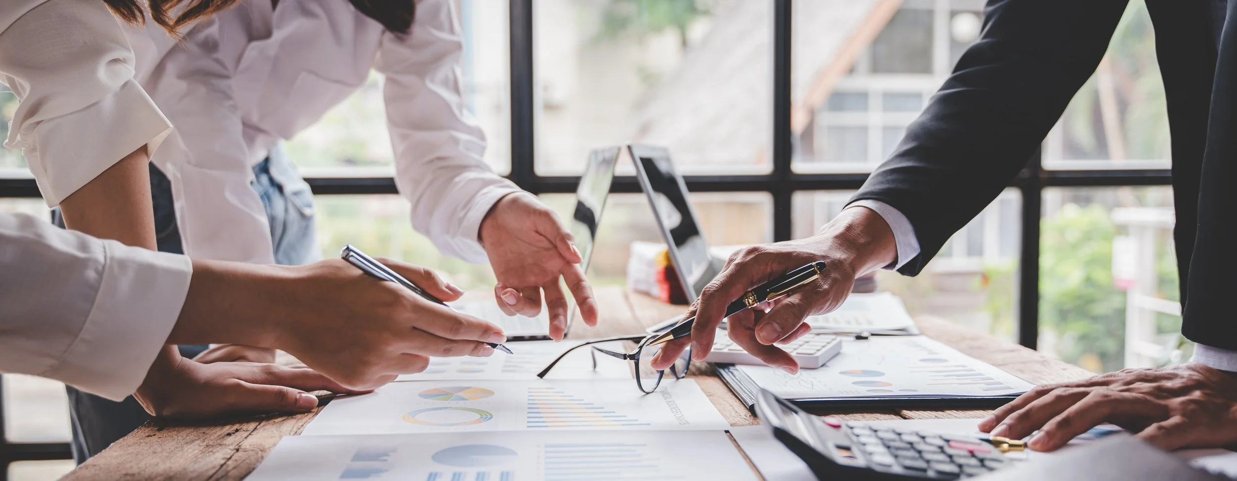 Team of business professionals reviewing contracts and financial paperwork