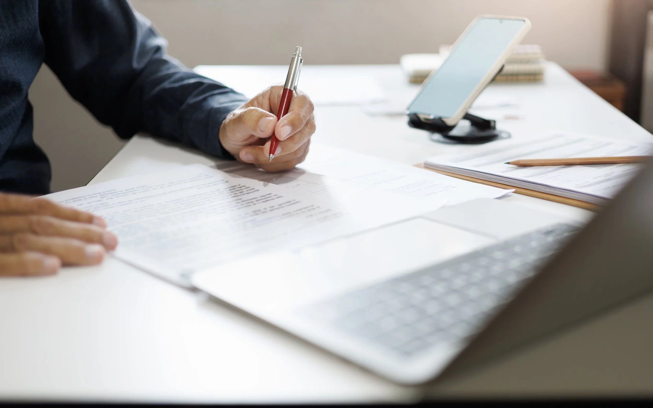 Professional writing on documents while preparing business tax return