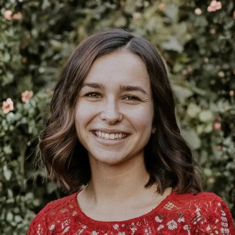 nicole fuller outdoors smiling at the camera with short brown wavy hair