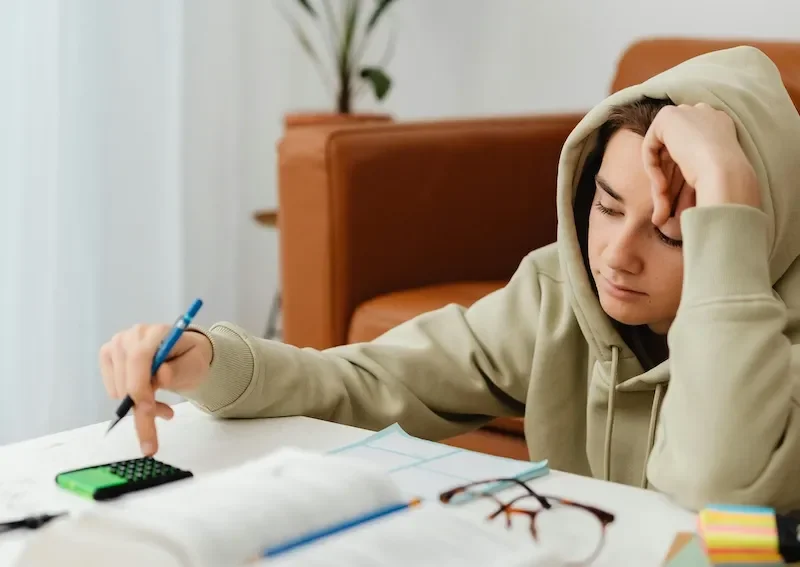 teen doing homework looking bored