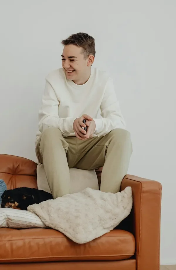 teen boy sitting on sofa smiling