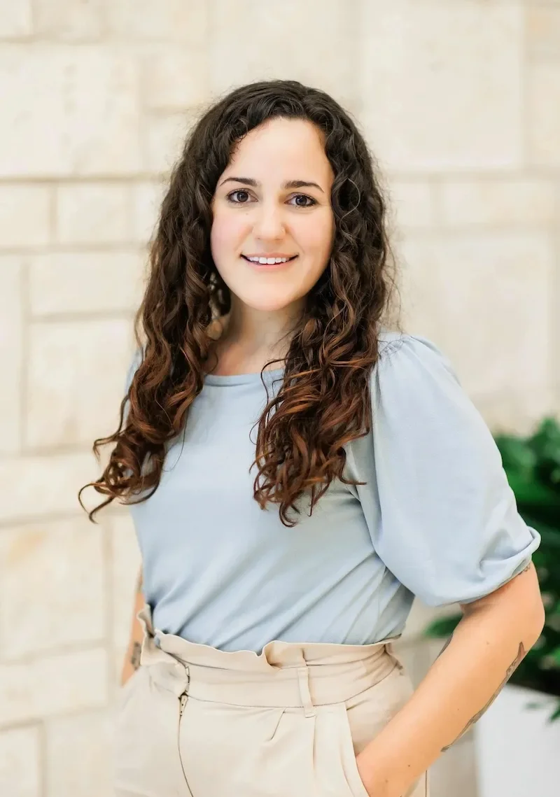 faith rutz smiling at the camera with long brown curly hair