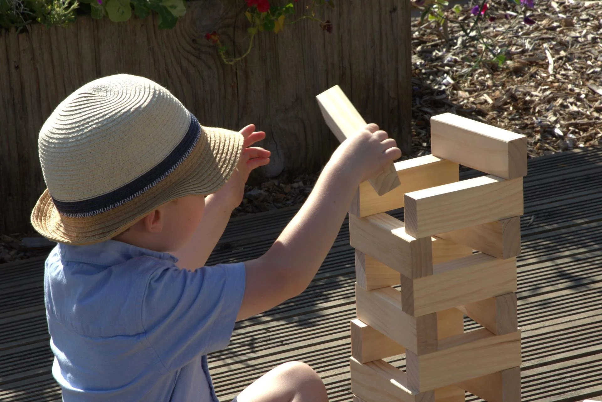 Child building tower with Giant Jenga Blocks
