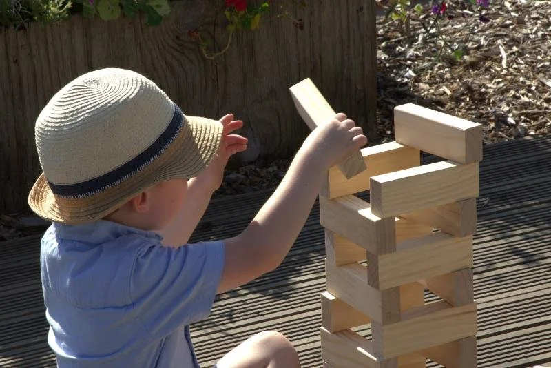 A child stacking giant wooden blocks game