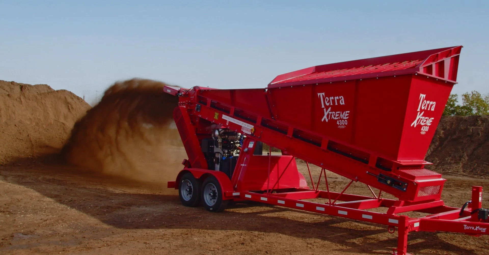 A red Terra Xtreme 4300 dirt dozer displaces soil on a construction site.