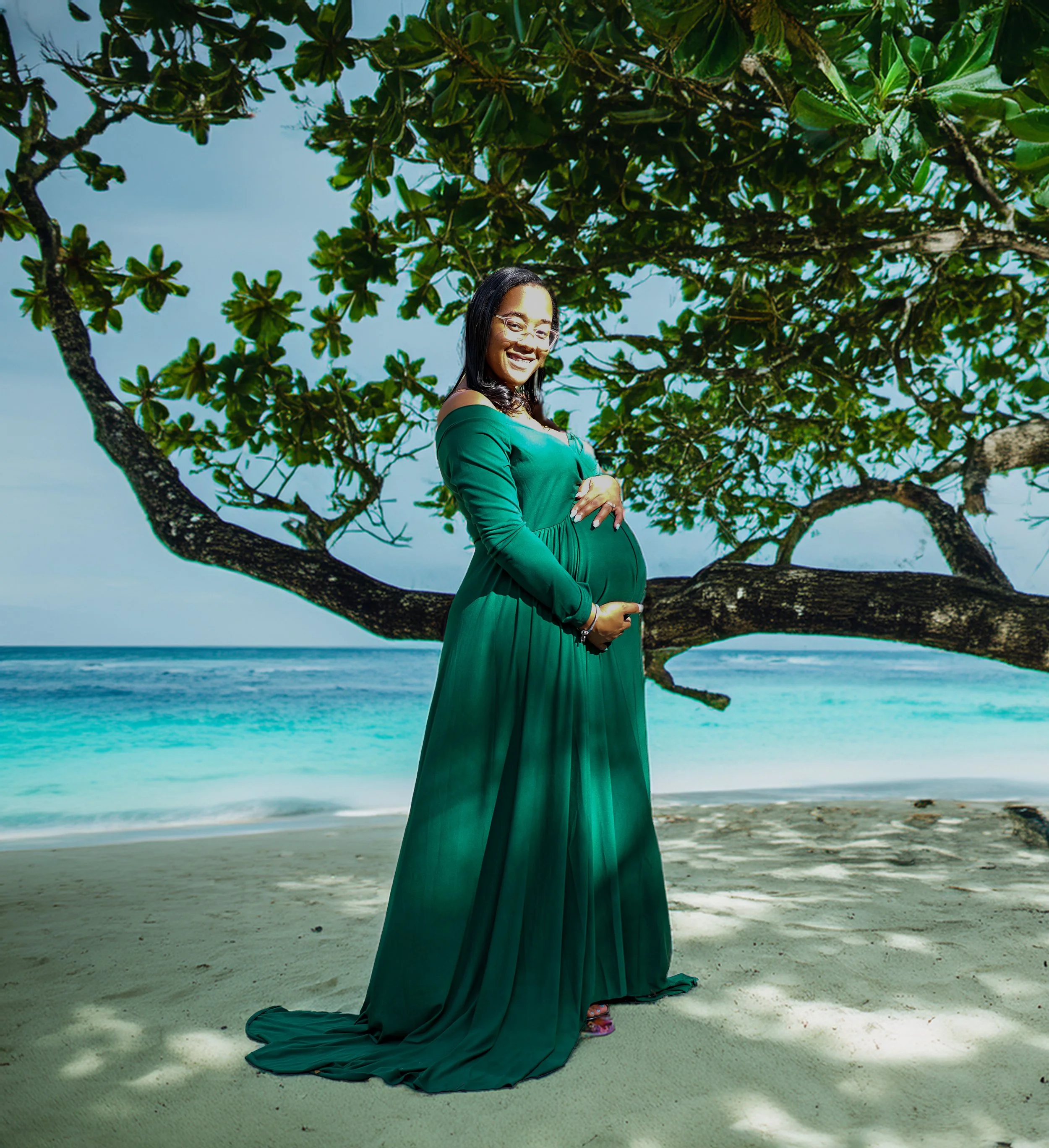 Pregnant lady in green dress on the beach 