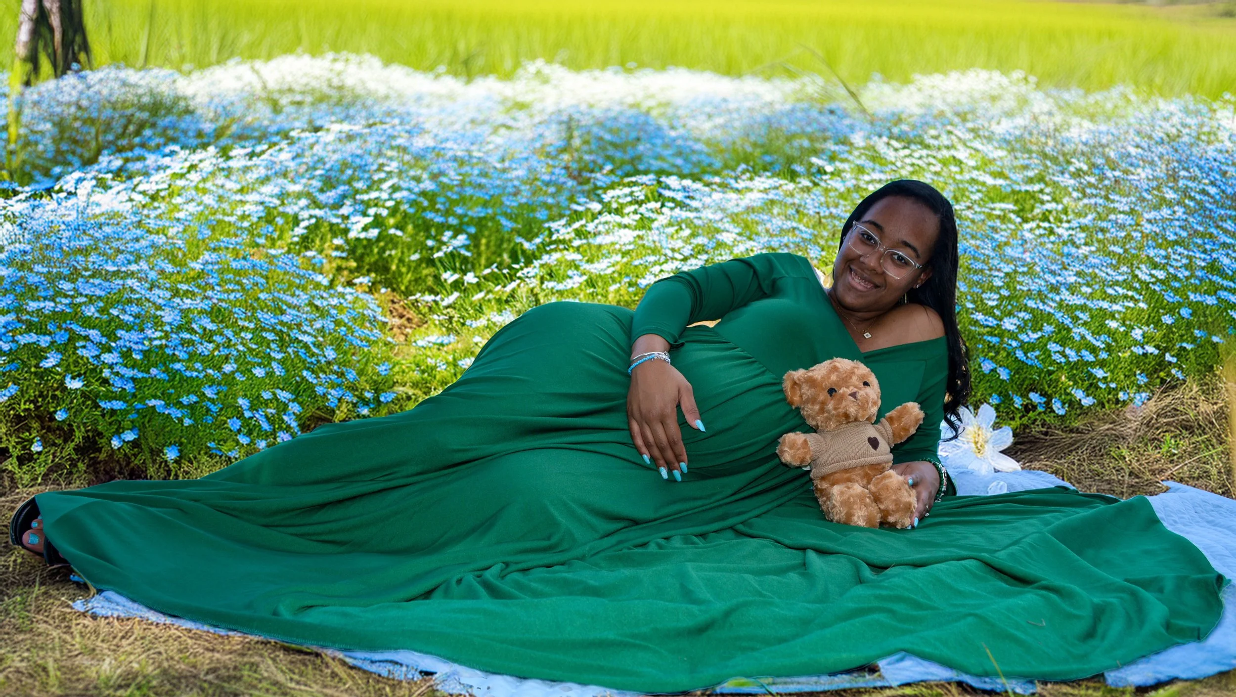 Pregnant mother in wildflower pasture with a teddy bear