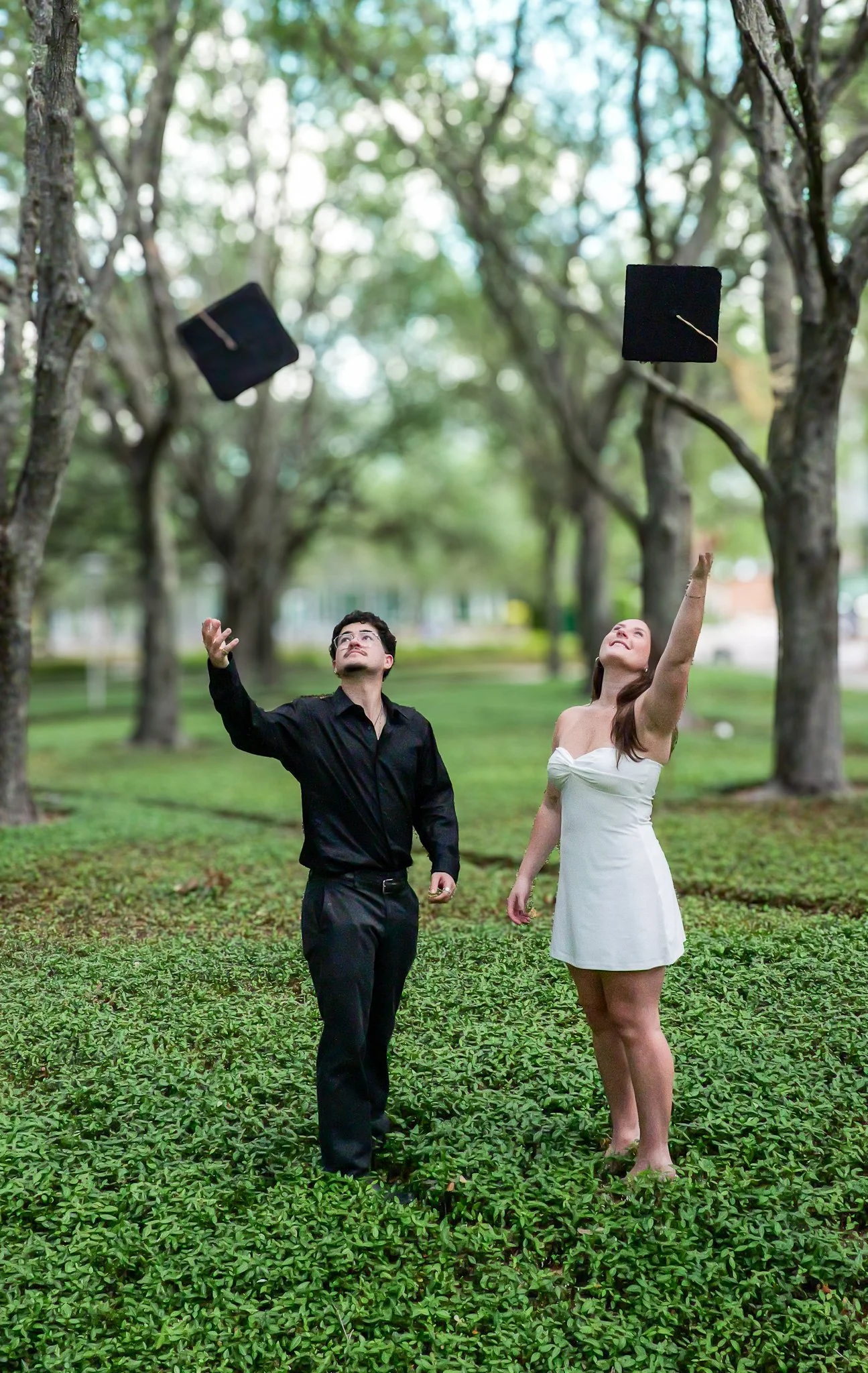 boy and girl throwing caps in the air graduation