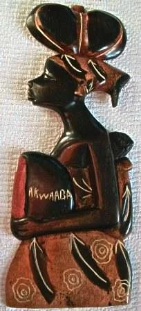 carrying an akwaaba in her front child on her back and vase on her head.jpg
