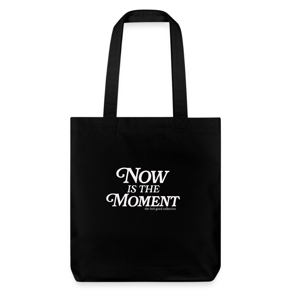 Schwarze Tragetasche mit weißem Text: 'NOW IS THE MOMENT' und kleiner Schrift darunter: 'the feel good collective'
