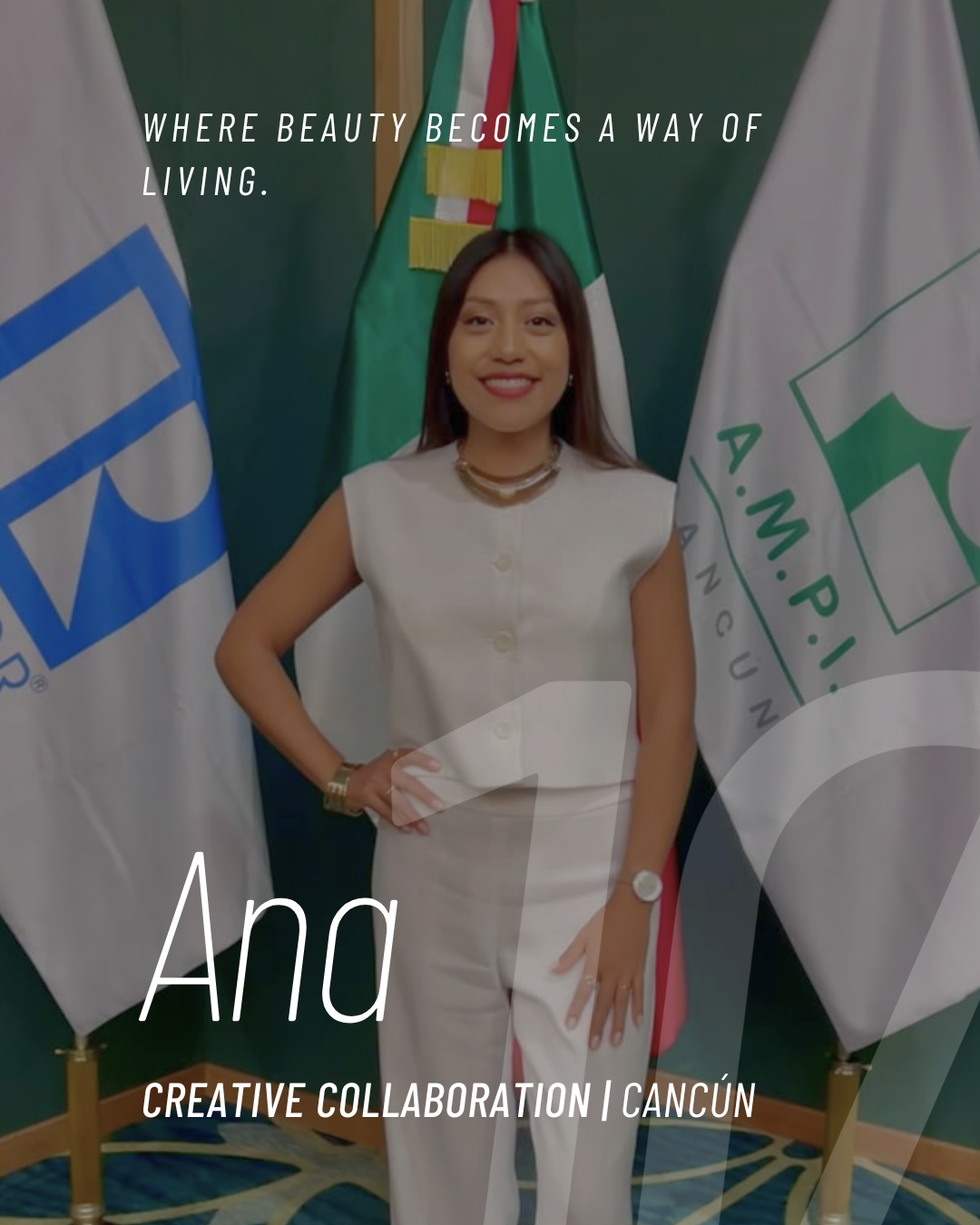 A woman in a white suit standing in front of flags, smiling at the camera.