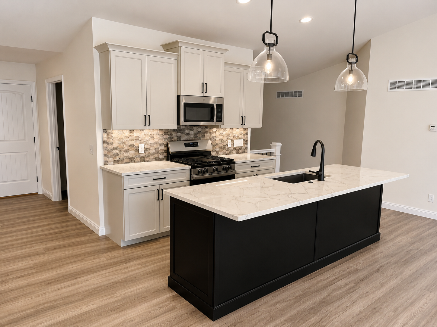 Modern kitchen with black island, white cabinets, gray backsplash, stainless steel appliances, wood flooring, and pendant lights