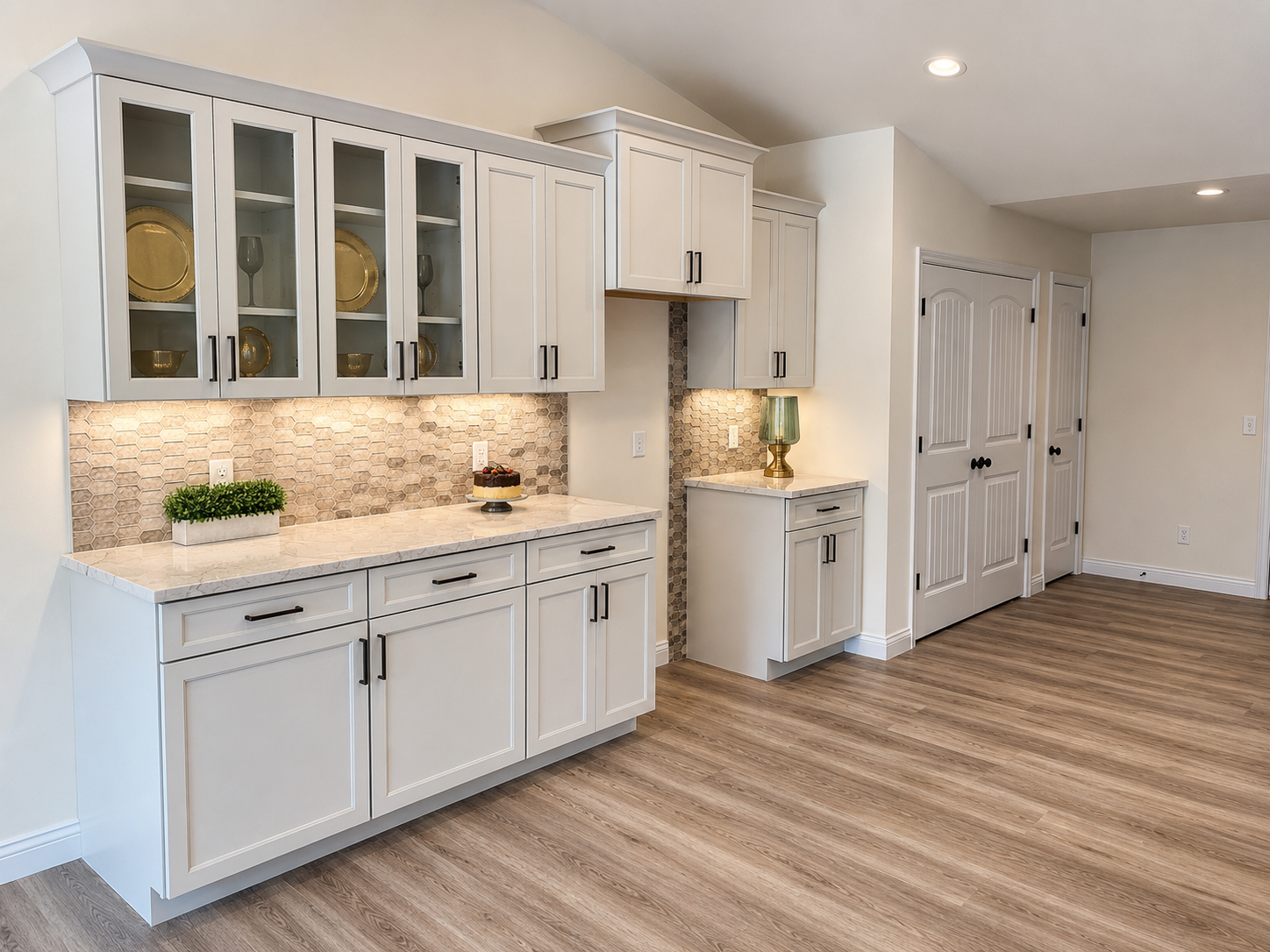 Modern kitchen with white cabinets, marble countertops, a hexagon tile backsplash, and hardwood flooring.