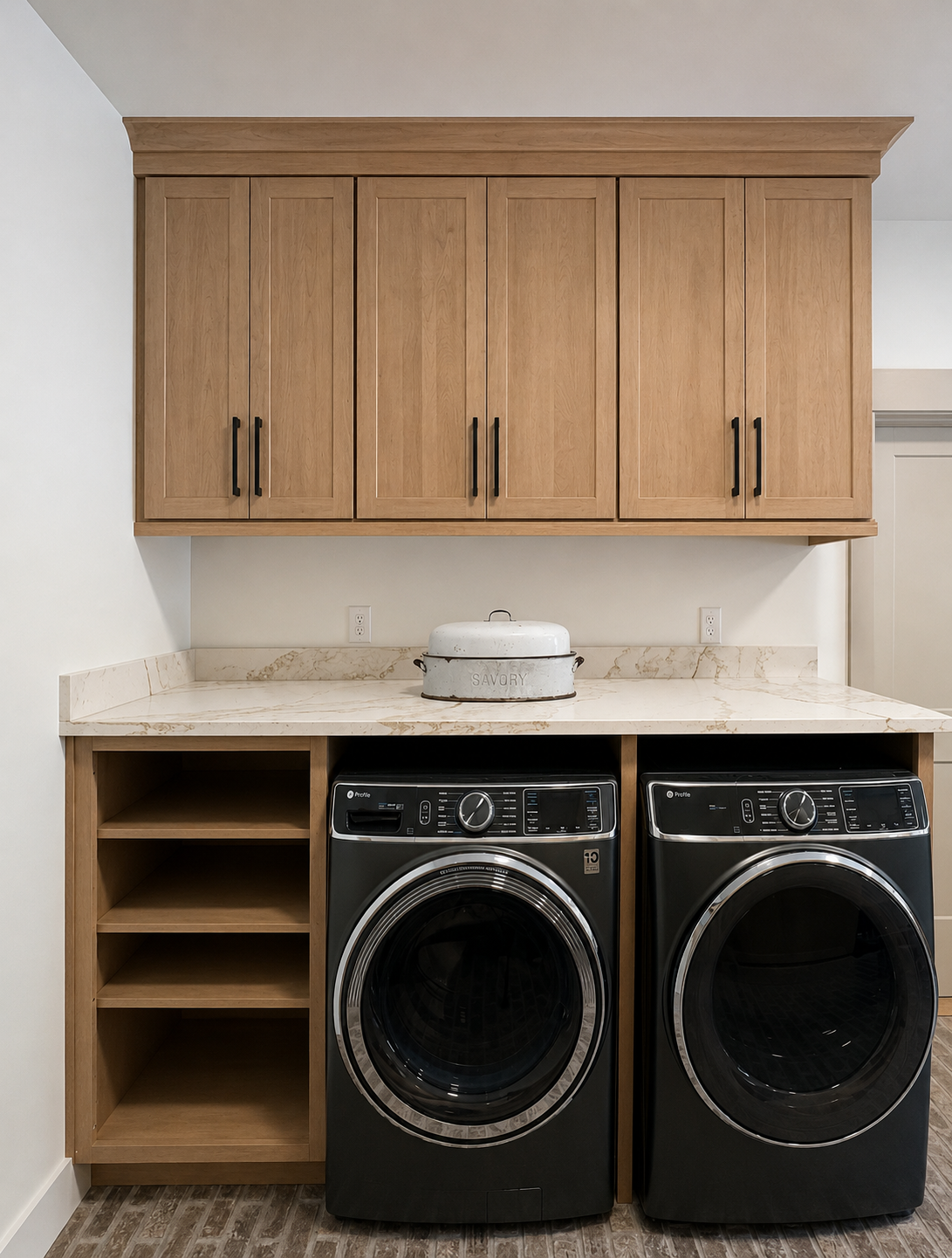 Front view of a laundry room with wooden cabinets, a marble countertop, and a washer and dryer.