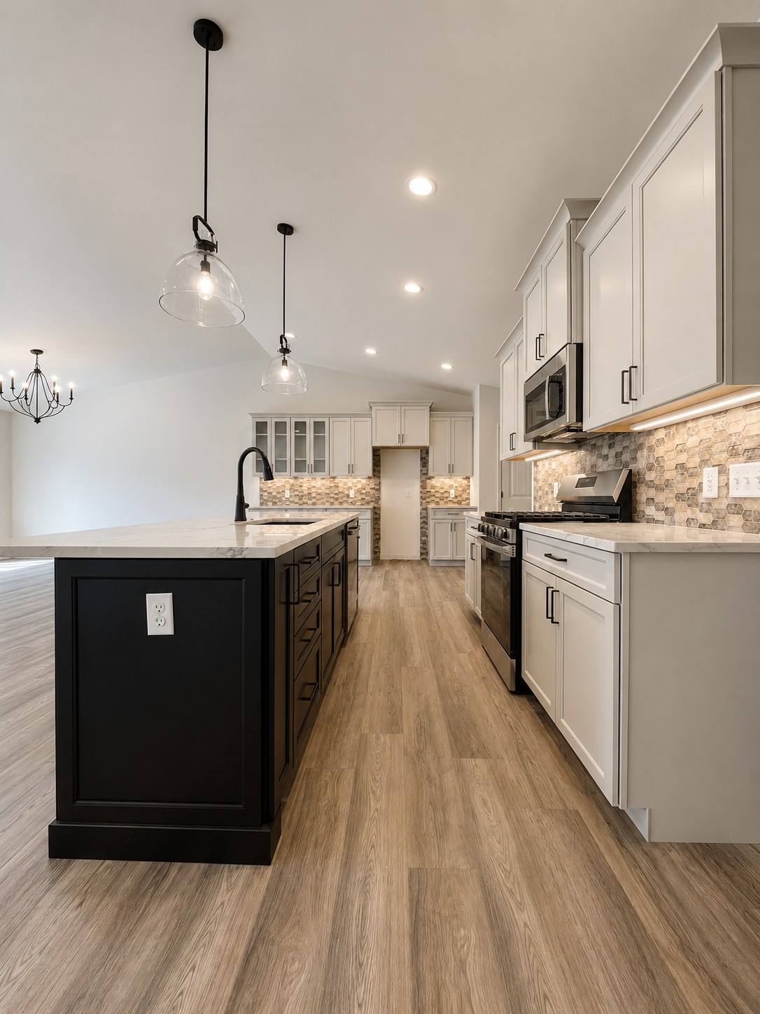 Modern kitchen with white and black cabinetry, wood flooring, marble countertops, stainless steel appliances, and honeycomb tile backsplash.