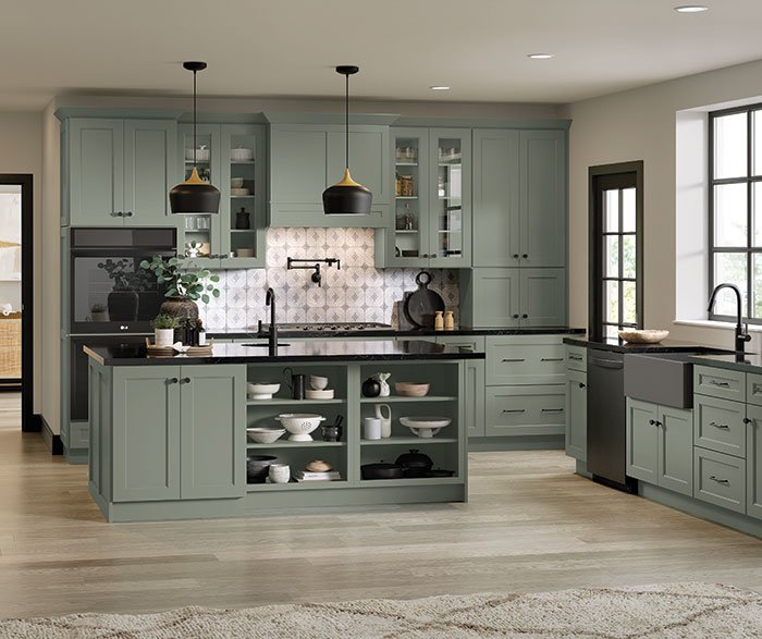 Modern kitchen with light green cabinets, kitchen island, open shelving, black accents, and natural light from large windows.