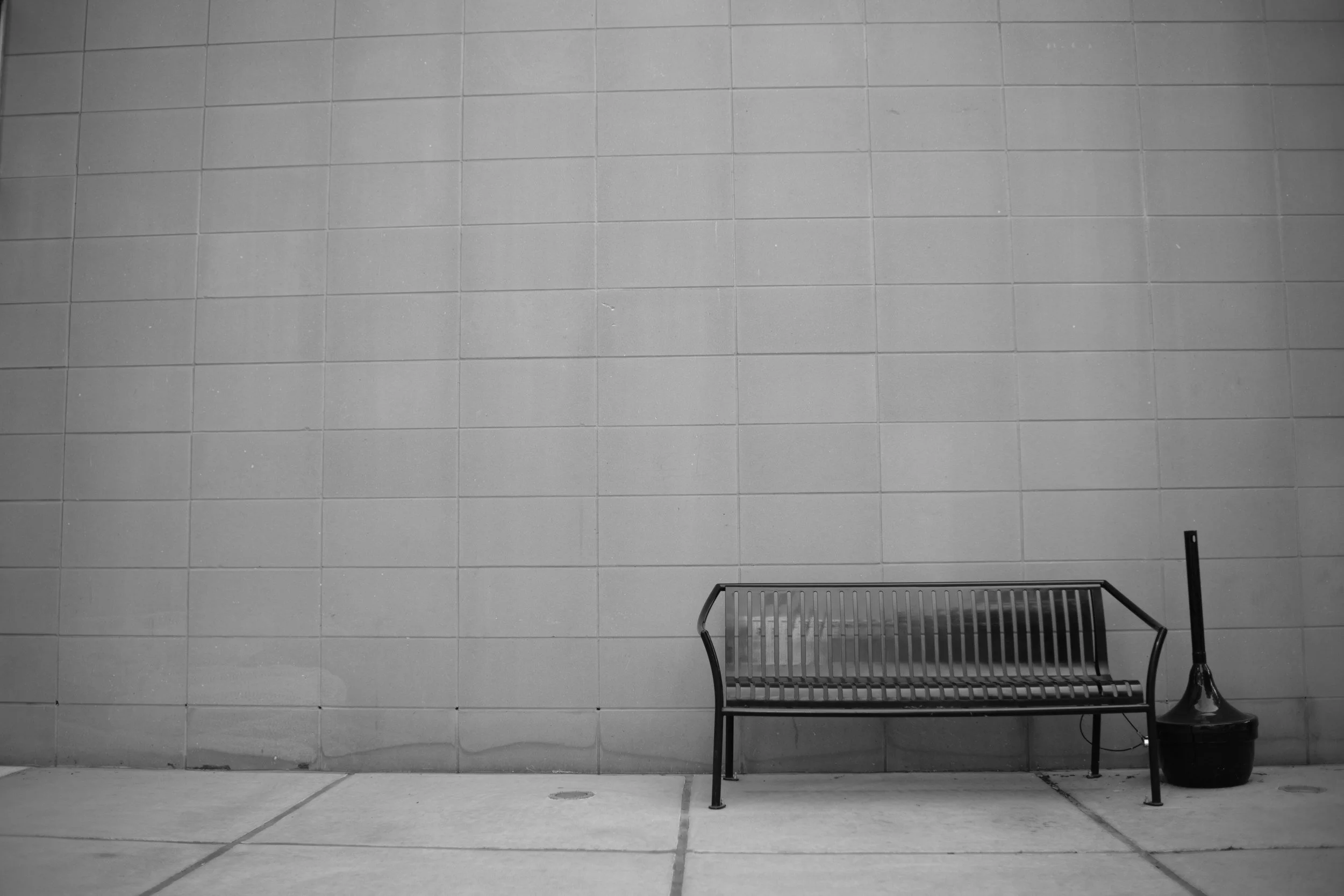 A bench against an empty wall. Seating for exactly one thought at a time.