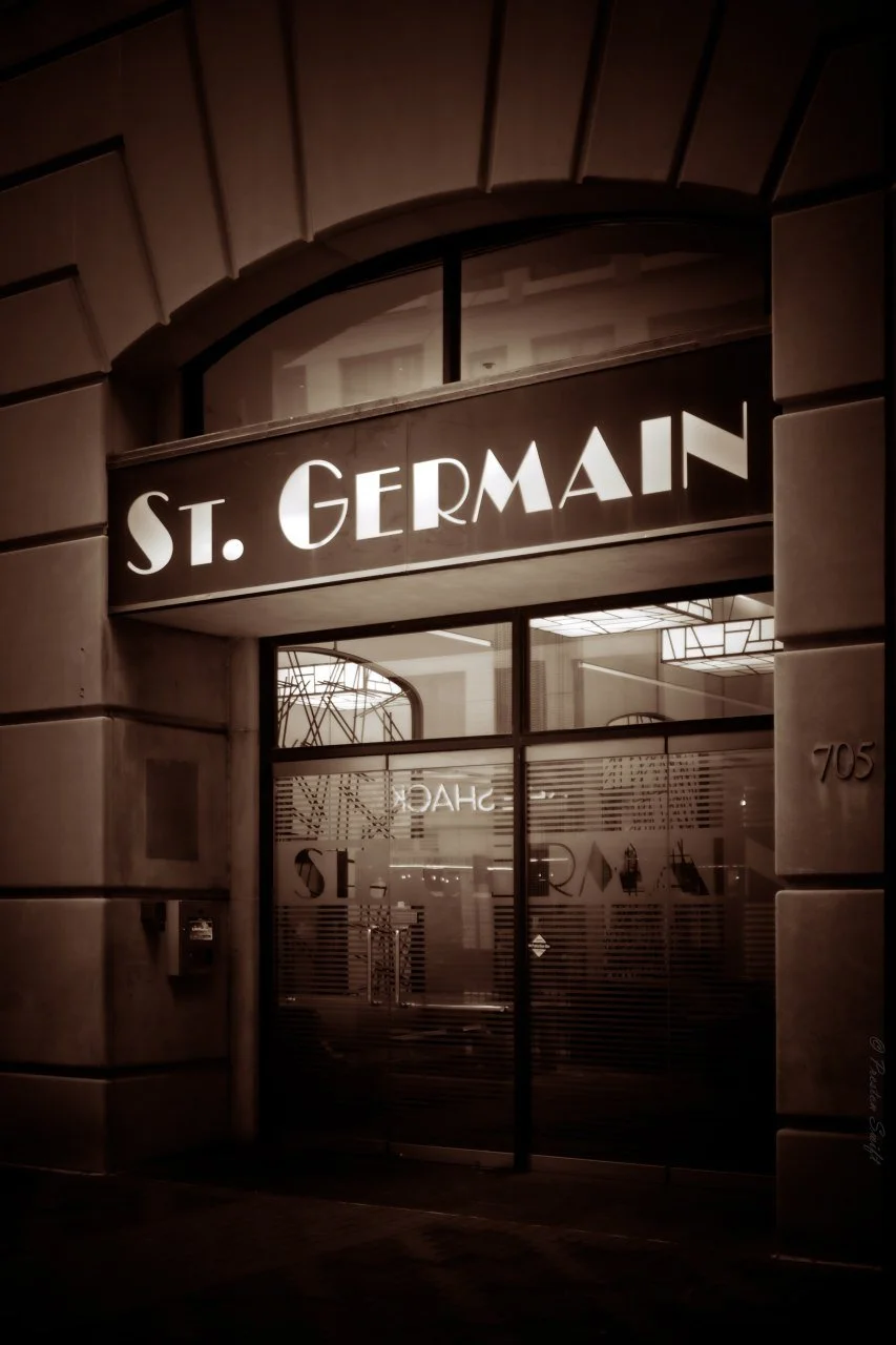 A storefront glowing under its own name after hours.