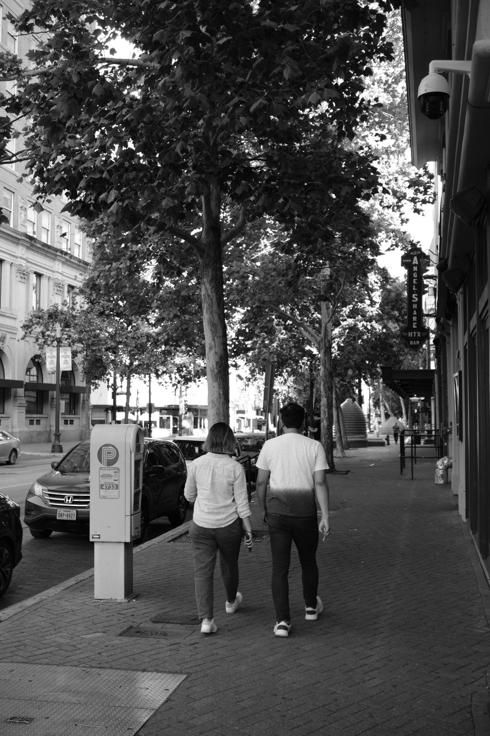 A couple walks Main Street in the shade.