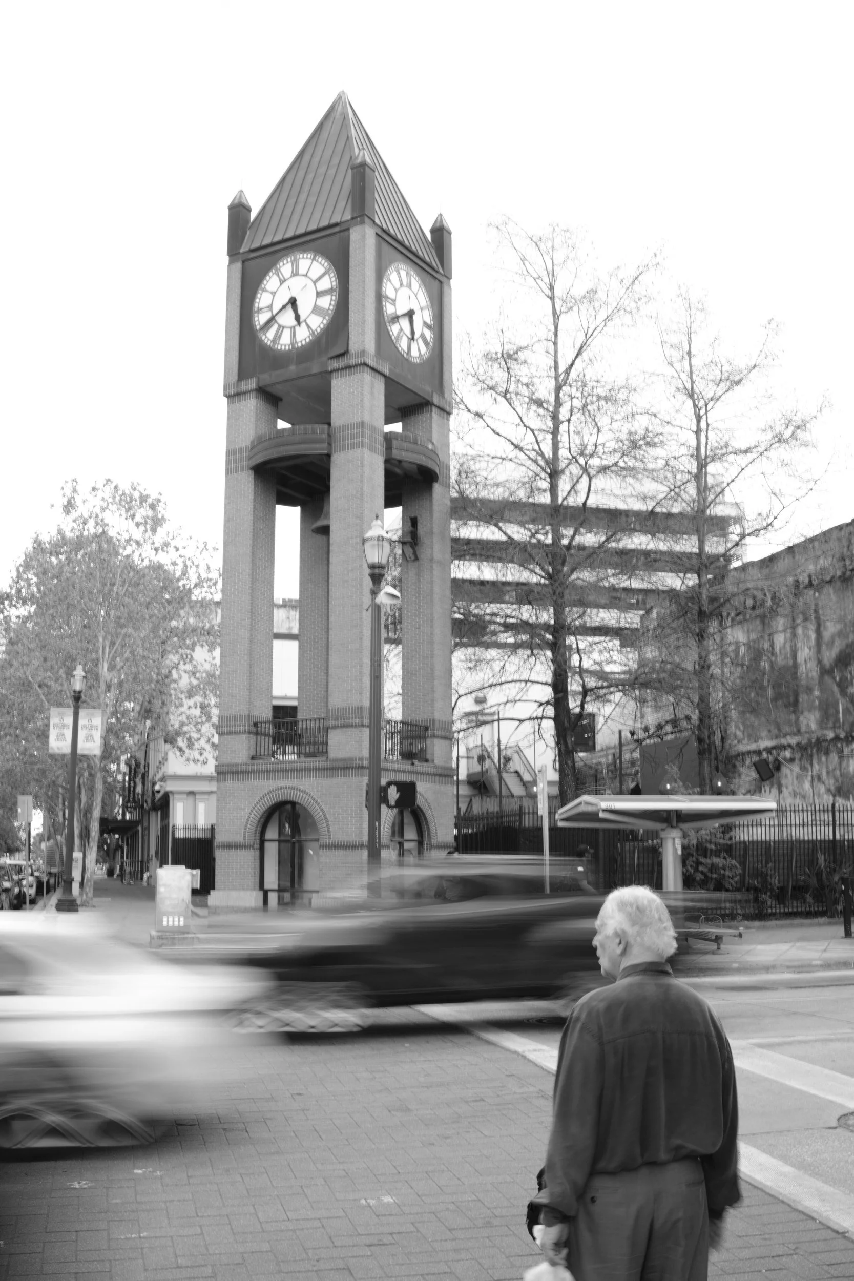 Traffic blurs past while the tower keeps perfect time.