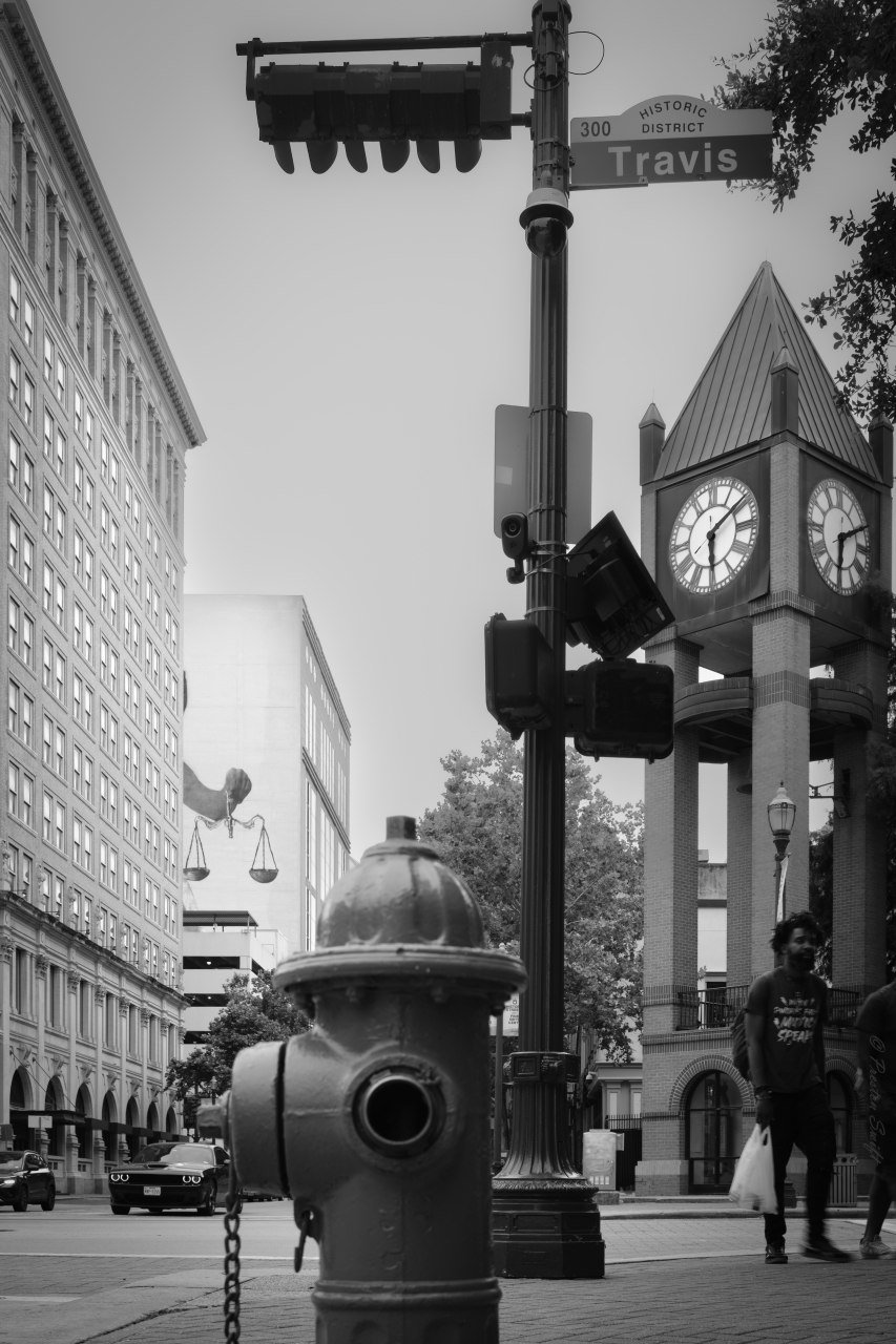 A hydrant in front of the clock tower on Travis Street.