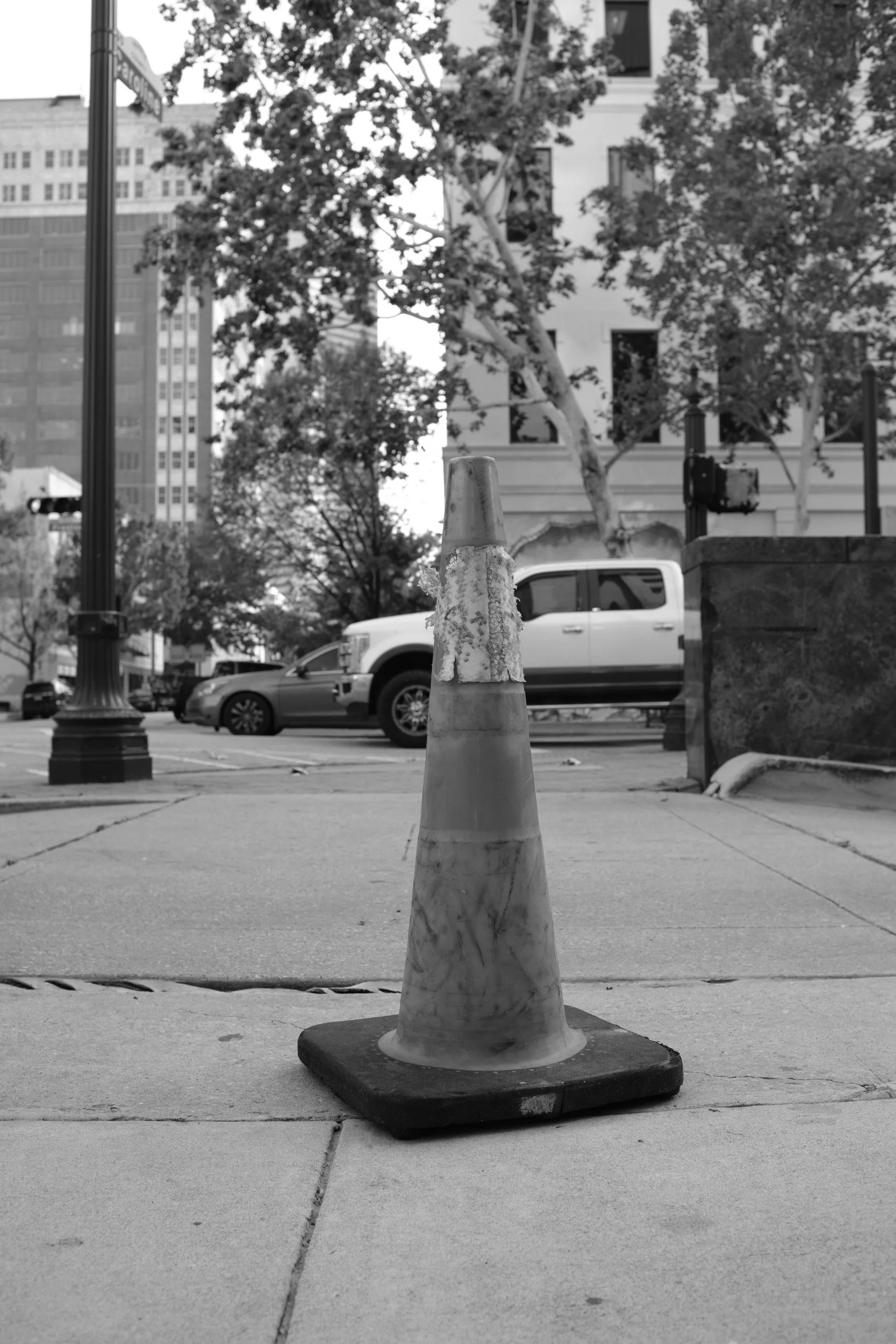 A traffic cone with the posture of a monument.